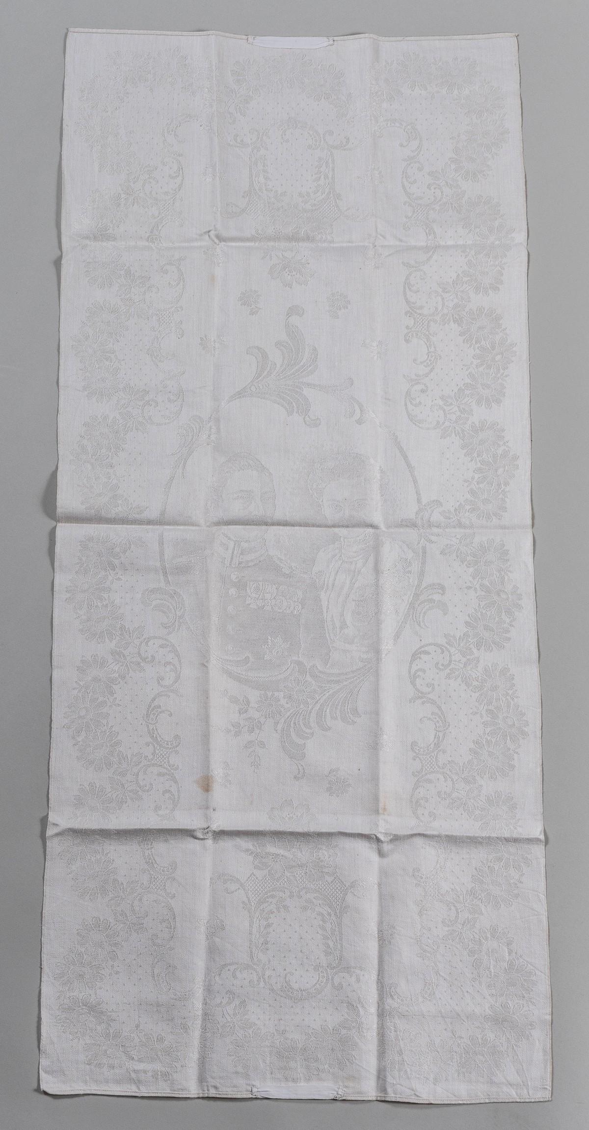 WILHELM II AND AUGUSTA VICTORIA TABLE RUNNER: White damask table cloth with the woven image of Wilhelm II, German Emperor and King of Prussia with his wife, Augusta Victoria, German Empress and Queen of Prussia. Surrounded by flowers and filigree