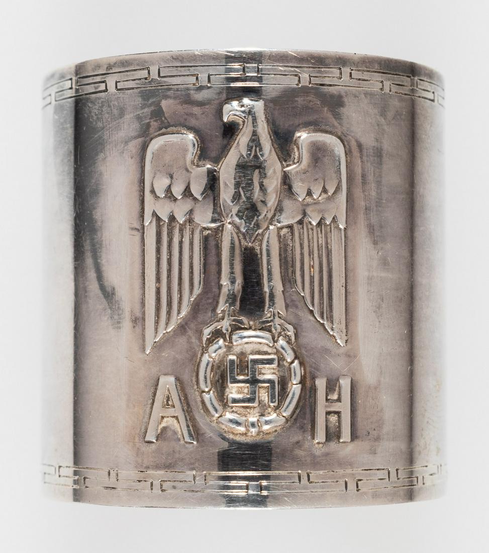 ADOLF HITLER FORMAL SERVICE NAPKIN RING: Original formal silver napkin ring from one of Hitler's formal dinner services, 1.75 in. (45mm) tall, 1 5/8 in. (43mm) diameter, bearing a large Nazi eagle and swastika device in relief, the swastika