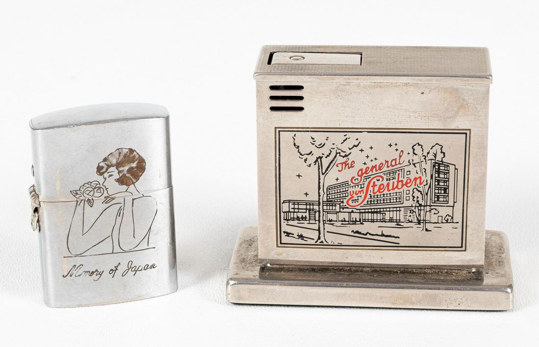 US MILITARY CIGARETTE LIGHTERS (2): Lot of two cigarette lighters: a table top lighter from the 'Headquarters United States Air Forces in Europe - Wiesbaden, Germany'. Engraved on the front with the image of 'The General von Steuben' ho