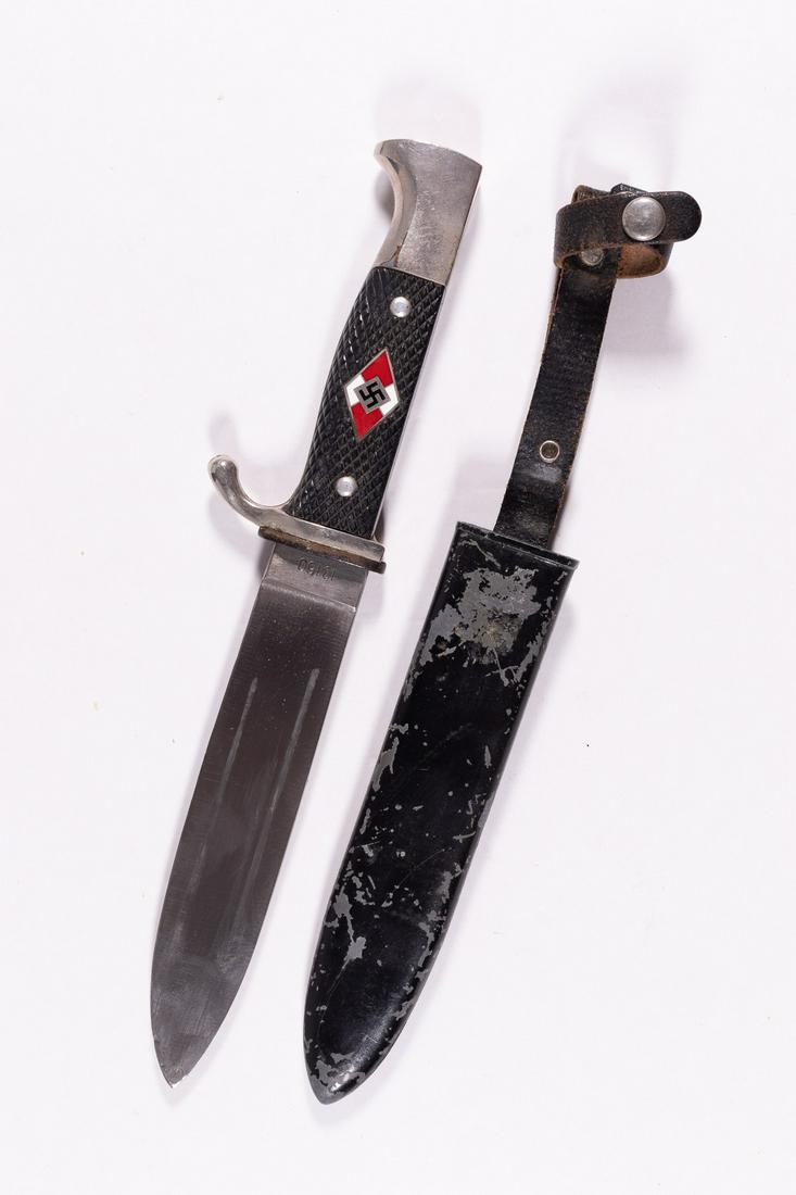 HITLER YOUTH DAGGER: Hitler Youth dagger with scabbard featuring an inlayed Hitler Youth symbol on the handle. Maker's mark, '13160' and reverse 'Solingen Germany'. Leather strap on scabbard has embossed 'Made in Germany'