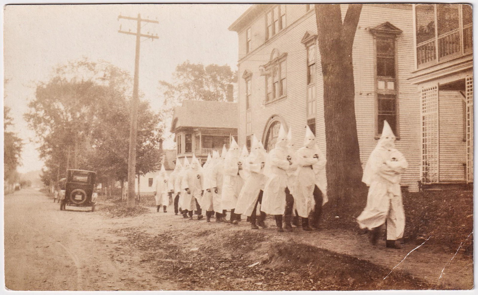 ORIGINAL 1920'S KU KLUX KLAN PHOTOGRAPHS (3): Lot of three original 1920's photographs of Ku Klux Klan groups marching through the streets. The photographs show hooded Klan members dressed in white robes with KKK symbols on their chests marching 