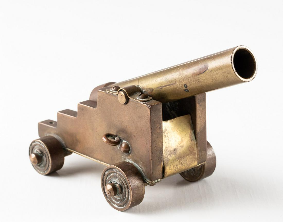 MINATURE BRASS CANON MADE IN SCOTTLAND: Miniature brass canon engraved on the bottom 'Hand Made in Scotland'. Movable wheels and barrel. 5.5 x 2.5 inches.