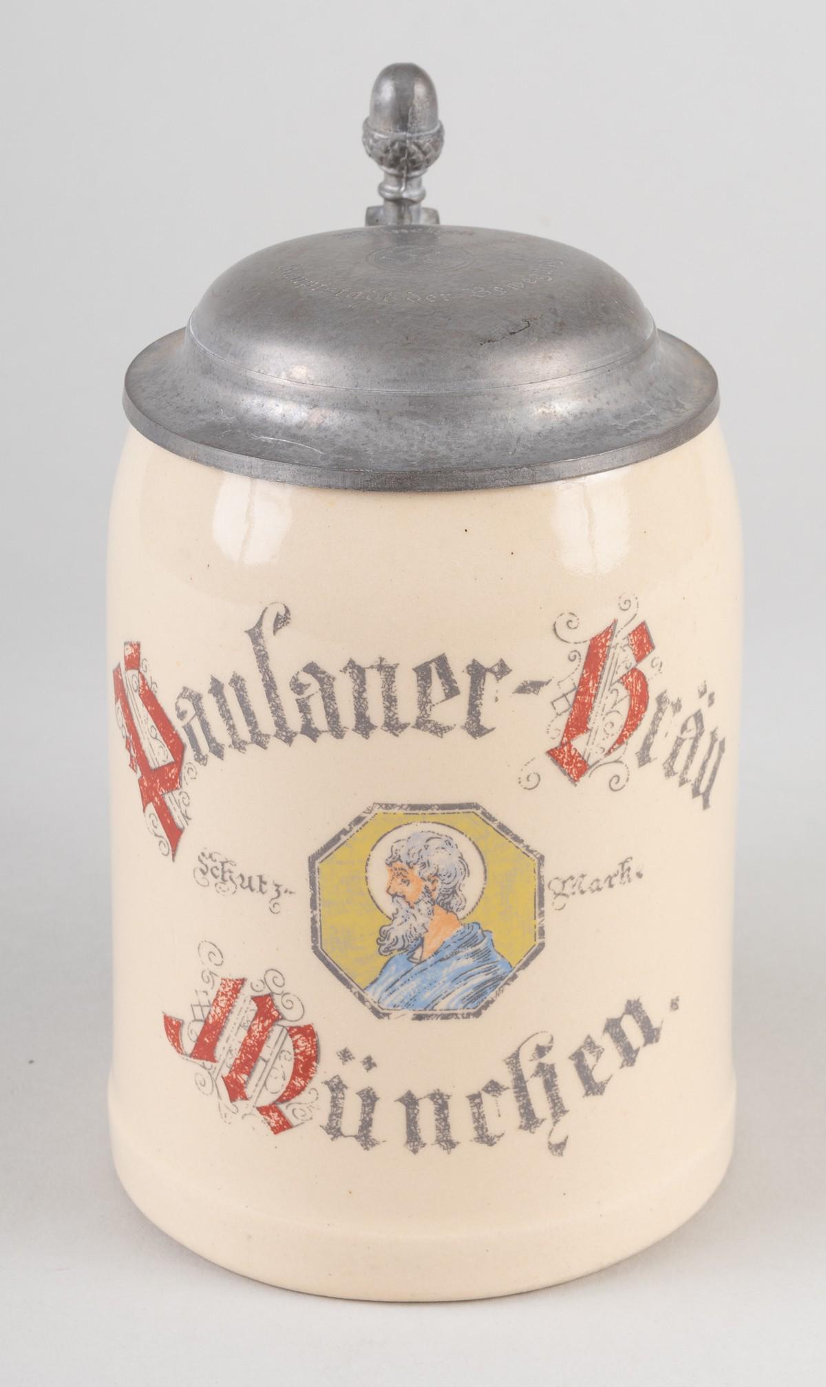 MUNICH NAZI BEER STEIN CAPITAL OF THE MOVEMENT: German WWII beer stein 'Paulaner-Brau Munich.' The pewter lid is engraved with a mobile swastika and 'Munich - Capital of the Movement' (Munchen - Haupstadt der Bewegung). The stein bears a portrait o