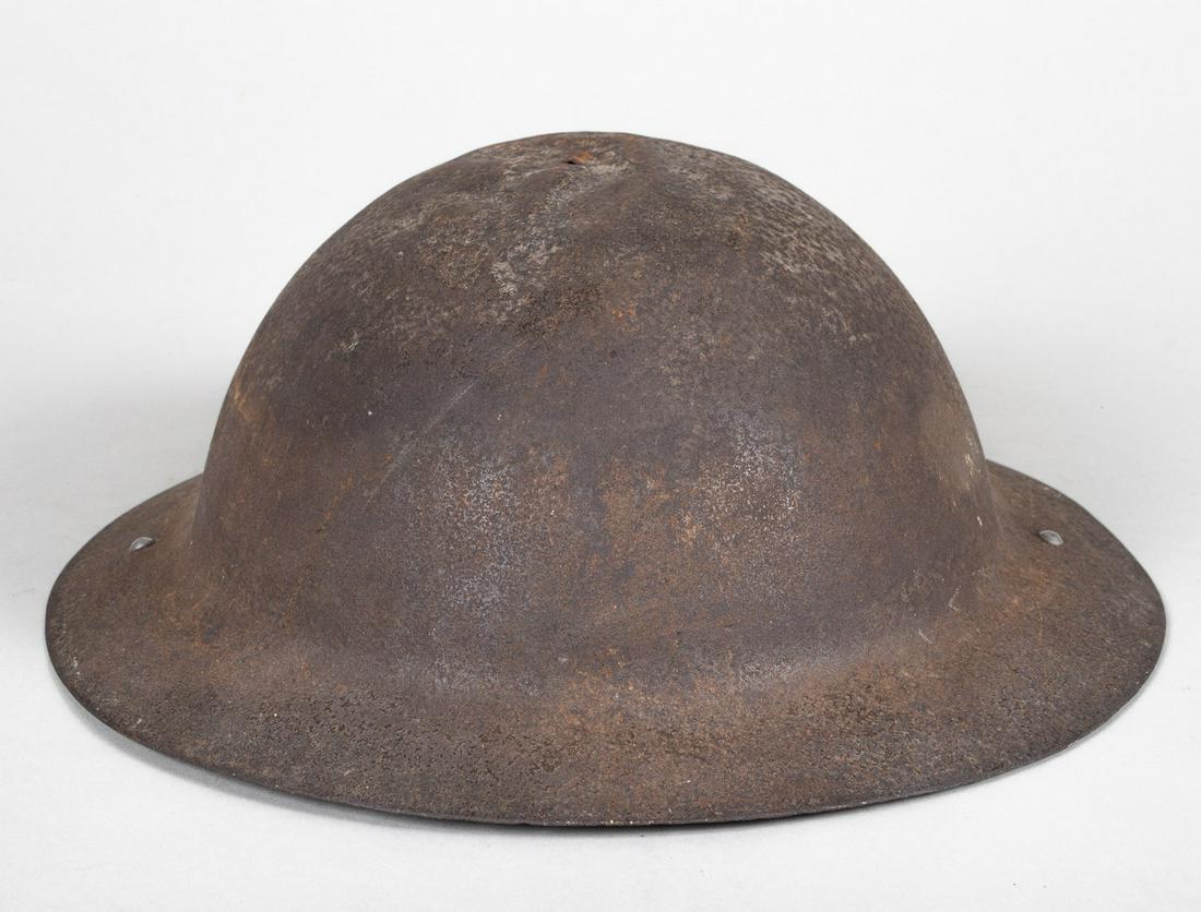 WWI BRITISH MARK I BRODIE HELMET: WWI British Mark I Brodie helmet in dug condition, no liner. Two newer chinstrap hinges are rivetted to the helmet, marked 'II 1938'. Some dents to the shell from battle impact, pitted steel.