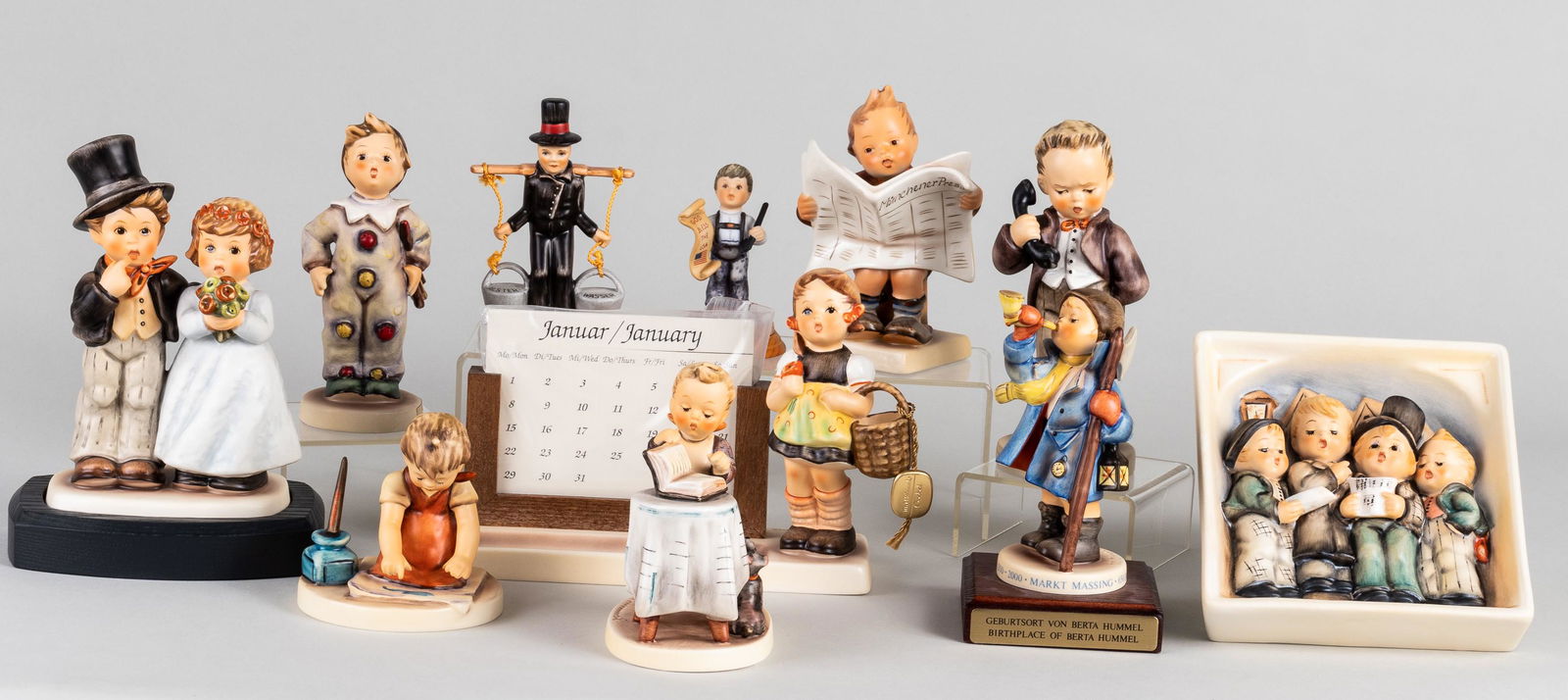 11 GOEBEL HUMMEL FIGURINES: Lot of eleven Goebel Hummel figurines, including 'Hear Ye, Hear Ye', 'The Birthplace of Berta Hummel', 'Dearly Beloved #1254', 'Little Bookkeeper', two 'Hello Perpetual Calendar #00011', 'Loving Greet