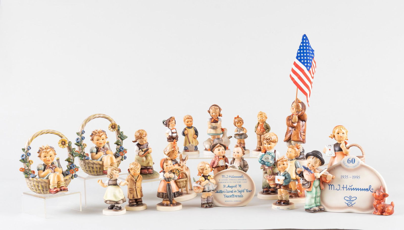 20 GOEBEL HUMMEL FIGURINES: Large lot of twenty assorted Goebel Hummel figurines, including a patriot boy carrying a star spangled banner.