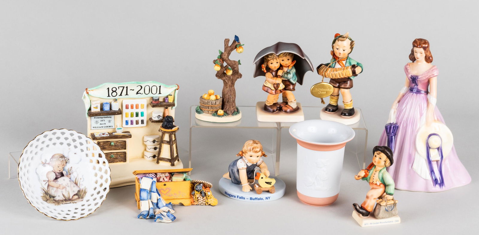 10 GOEBEL & HUMMEL FIGURINES AND MORE: Large lot of ten Goebel Hummel figurines, including 'Accordion Boy', 'Small Hope Chest', 'Stormy Weather', and others.
