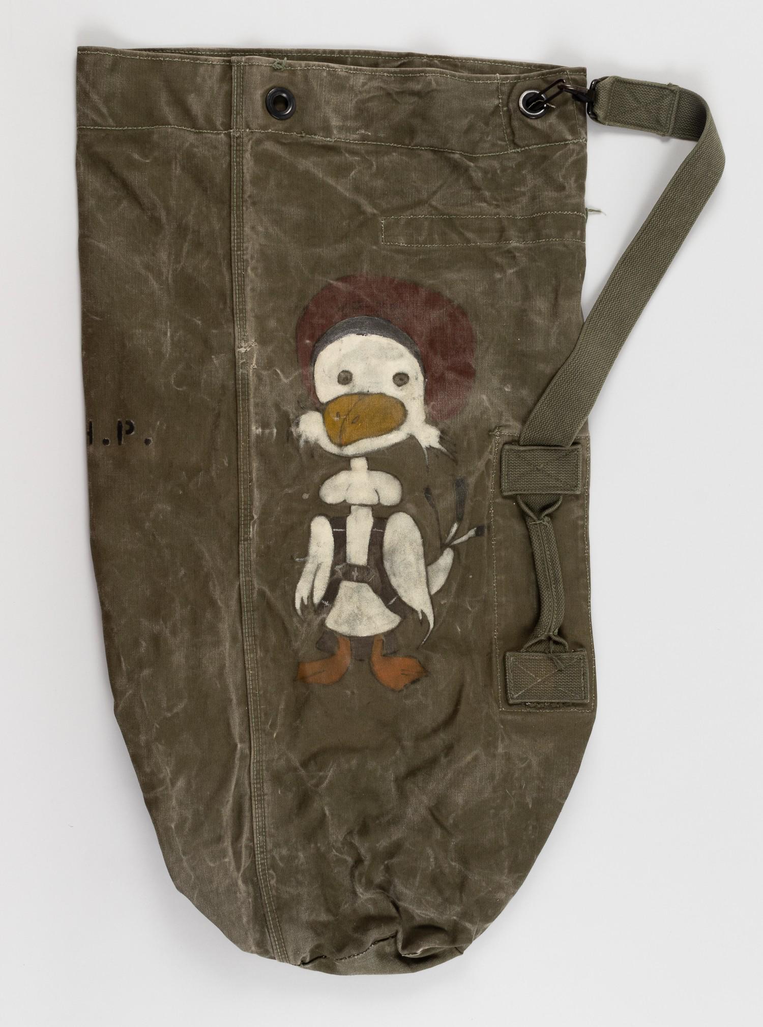 VIETNAM WAR GOONEY BIRD PAINTED SEABAG: Seabag from the Vietnam War featuring a large hand-painted 'Gooney Bird' once belonging to Photographer's Mate Third Class Henry P. Hagenau, an active service man during Vietnam who was assigned to a 