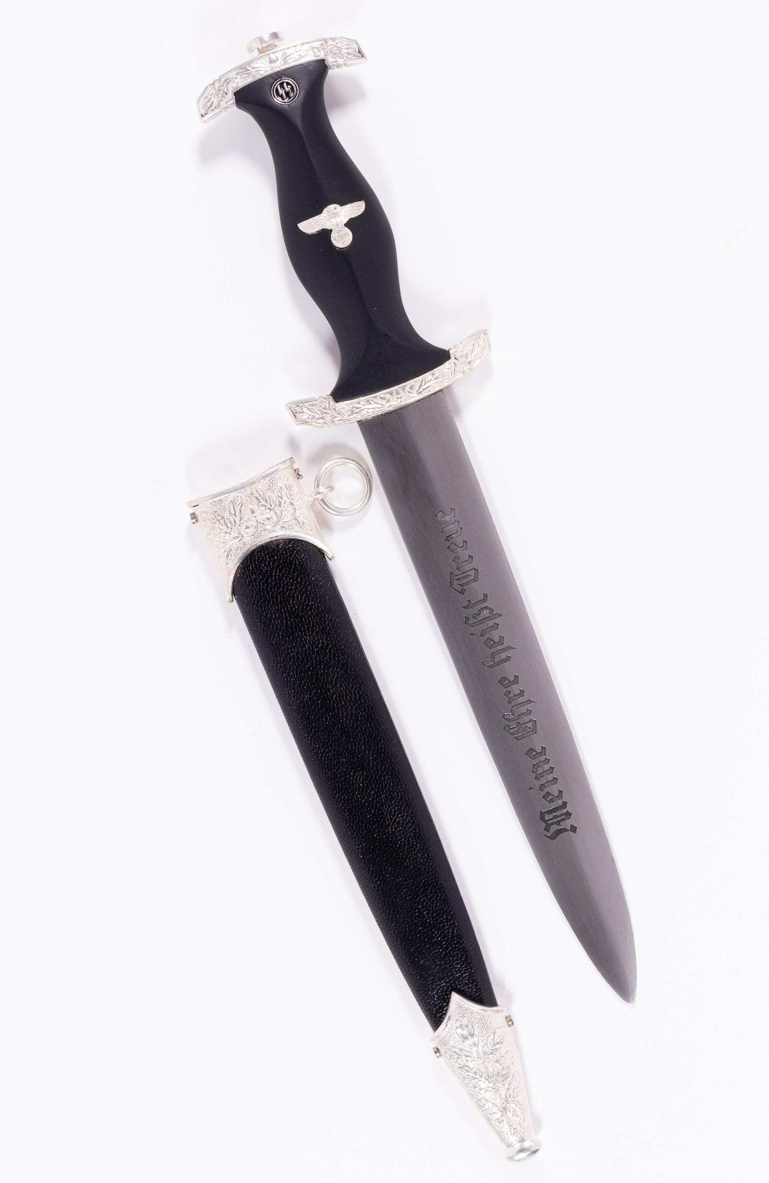 GERMAN REENACTMENT SS DAGGER: German WWII reenactment SS dagger. The dark ebony wood grip combines a Nazi eagle with the SS enamel emblem and plated zinc crossguards. The blade is etched with the motto 'Meine Ehre Heisst Treue' on
