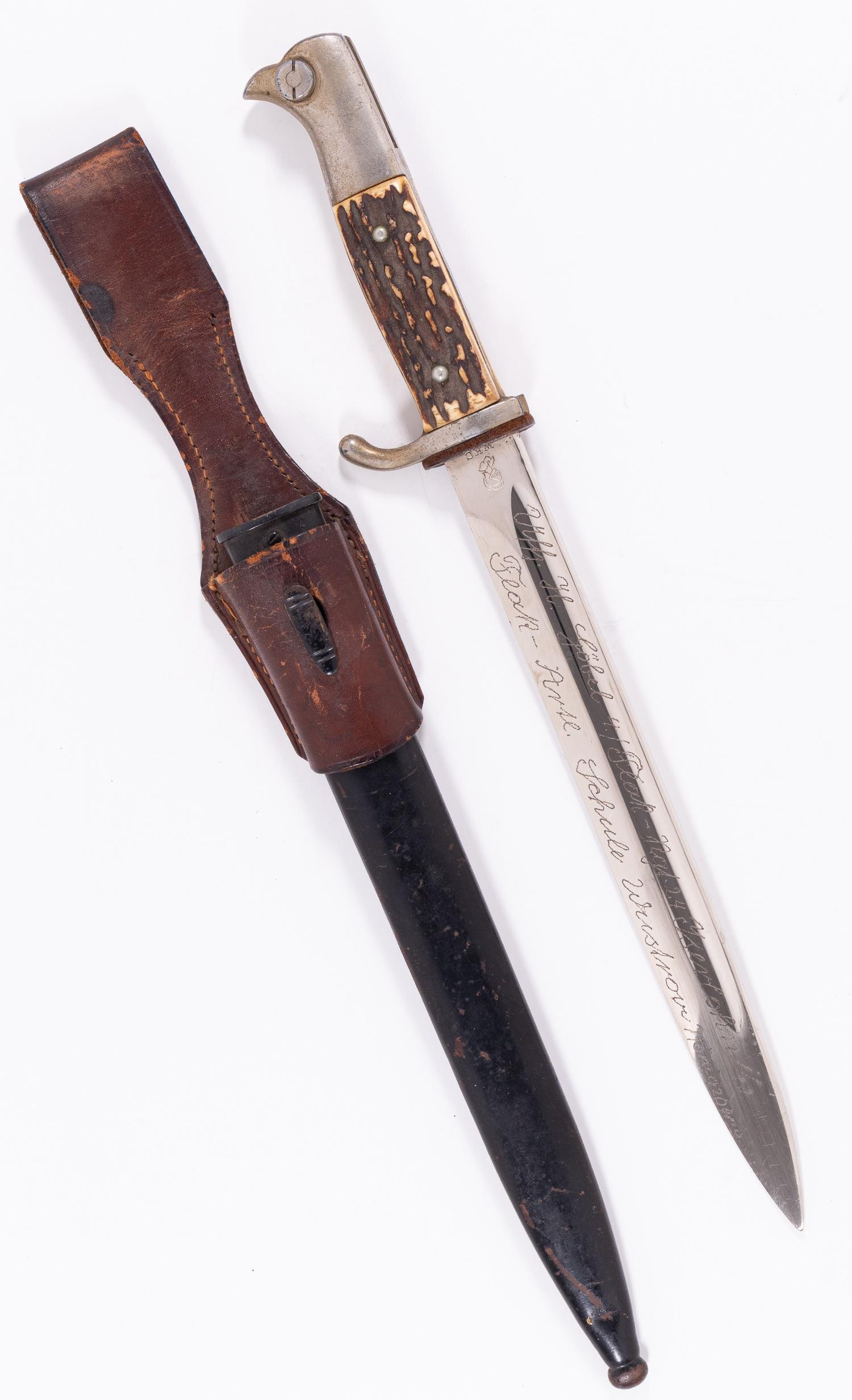 GERMAN WWII BAYONET WKC ENGRAVED: German WWII bayonet by WKC, stag grips, blade is engraved 'Uffz. H Gobel 4. Flak-Rgt. 34 Iserlohn Flak-Artl. Schule Wustrow Konigsberg'. Marked 'WKC'. With metal scabbard and brown leather frog. Wear 