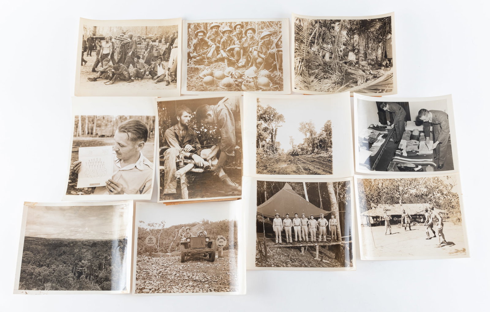 11 AMERICAN WWII PHOTOGRAPHS: Eleven American WWII photographs from the Solomon Islands and New Guinea. The photographs include U.S. soldiers capturing Japanese prisoners and taking loot, and Americans posing with dead Japanese so