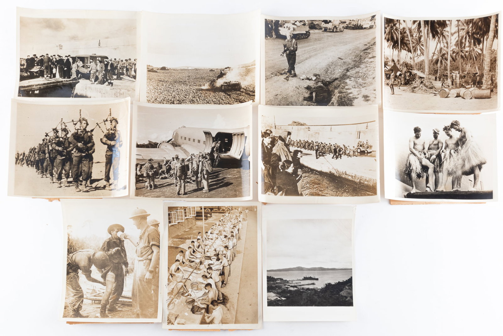11 AMERICAN WWII PHOTOGRAPHS: Eleven American WWII photographs from Italy, Tunisia, and New Guinea. Photographs include a British soldier walking beside a dead Italian and four U.S. airmen dressed as 'hula girls'. Some photographs