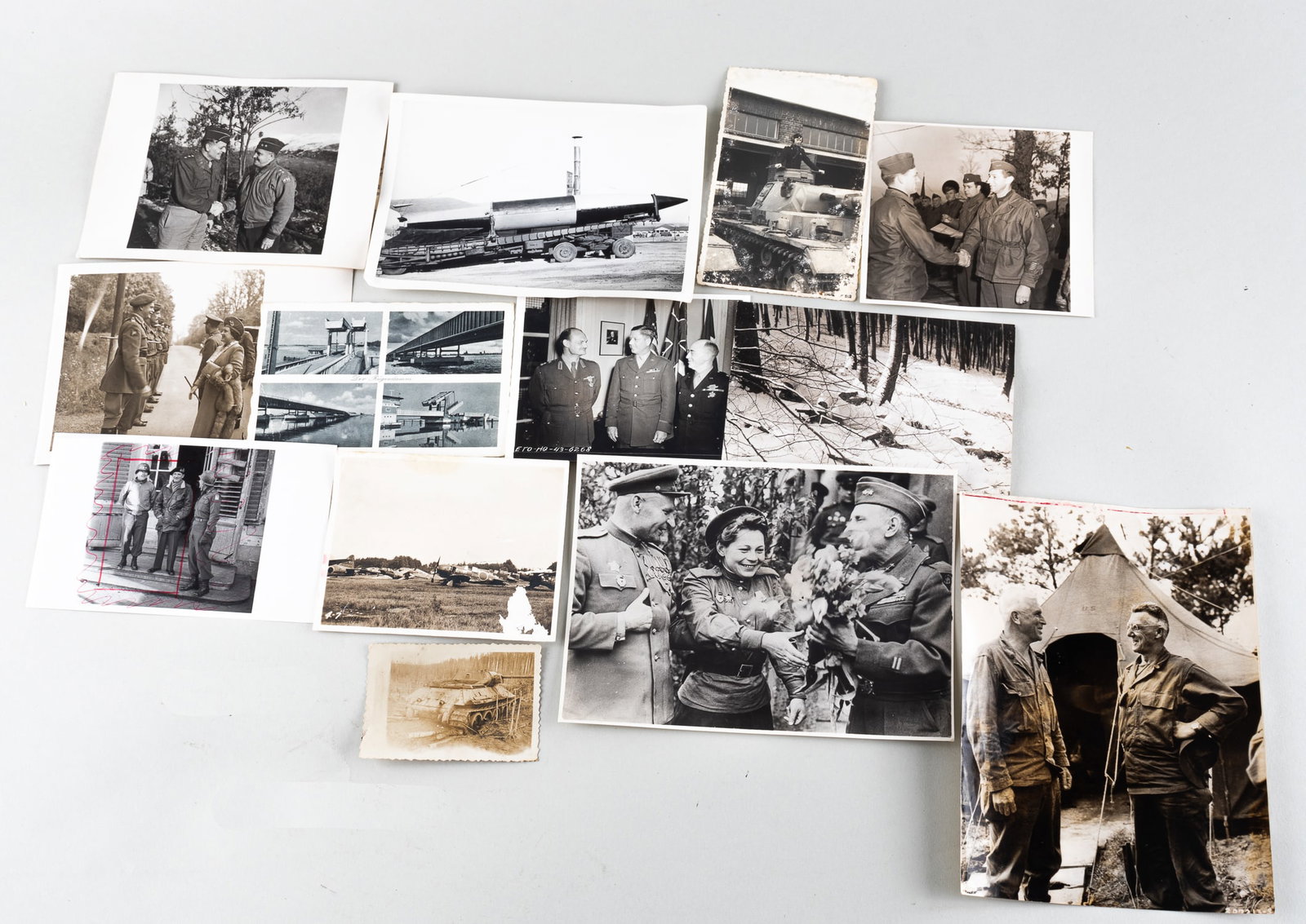 13 WWII PHOTOGRAPHS AND POSTCARDS: Thirteen WWII postcards and photographs. One postcard features photographs of a dam and a Waffen SS stamp on verso. Other images include a destroyed tank, the U.S. 7th Army lying in white camouflage w