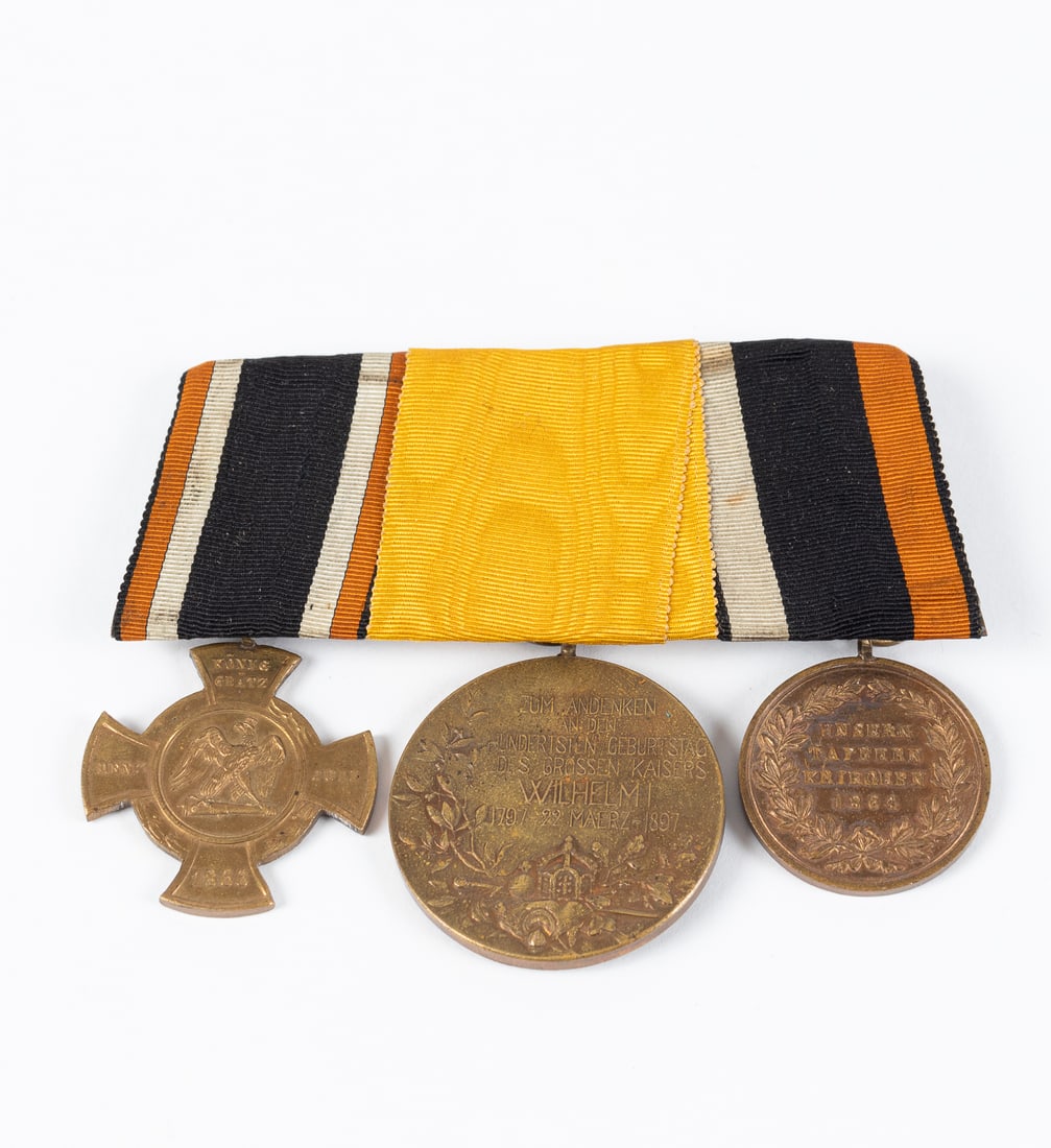 GERMAN AUSTRO-PRUSSIAN MEDAL BAR WITH DOCUMENTS: A German Austro-Prussian medal bar most likely belonging to Lorenz Eisen (1844-1900), a Prussian who eventually immigrated to New York City. The first medal is the Koniggratz Commemorative Cross. The 