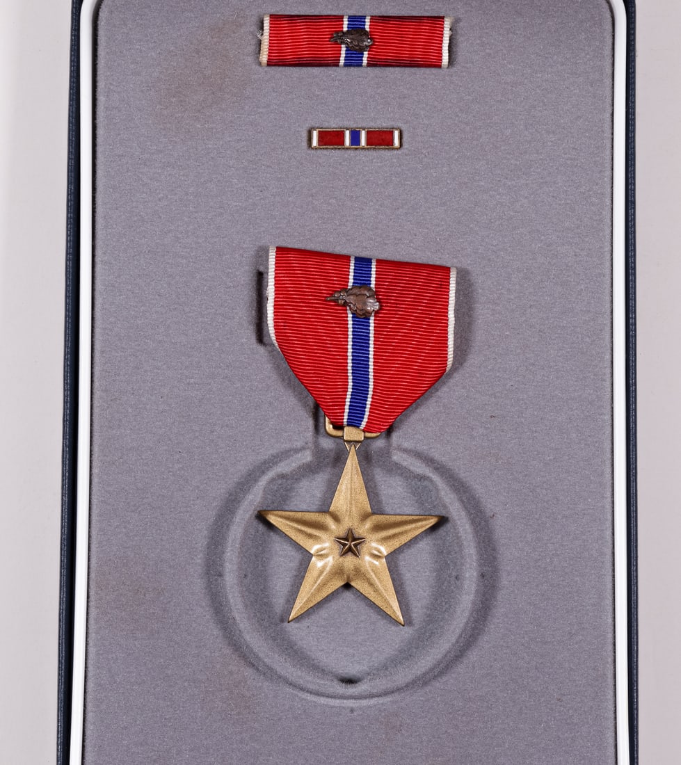 NAMED BRONZE STAR W/ OAK LEAF CLUSTER CASED: Named and cased US Bronze Star with bronze oak leaf cluster, service ribbon and lapel pin. The Bronze Star is engraved with the name of 'HARRY V. JONES JR.'