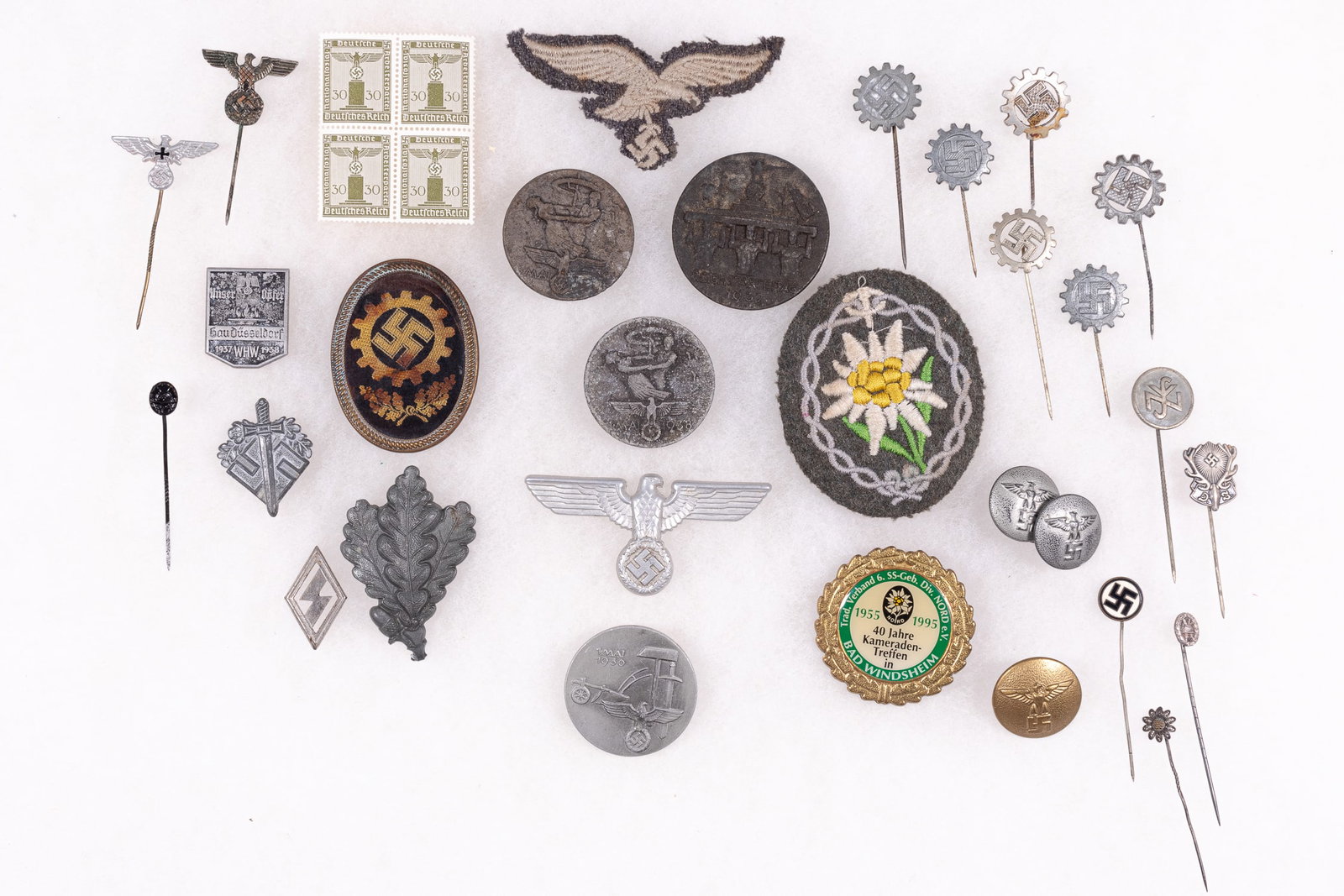 30 THIRD REICH GERMAN INSIGNIA: A group of 30 German Third Reich insignia that includes a pin for German hunters, a deer with a swastika in between the antlers. An S.A. leaders button, a gold button with an eagle holding a swastika.