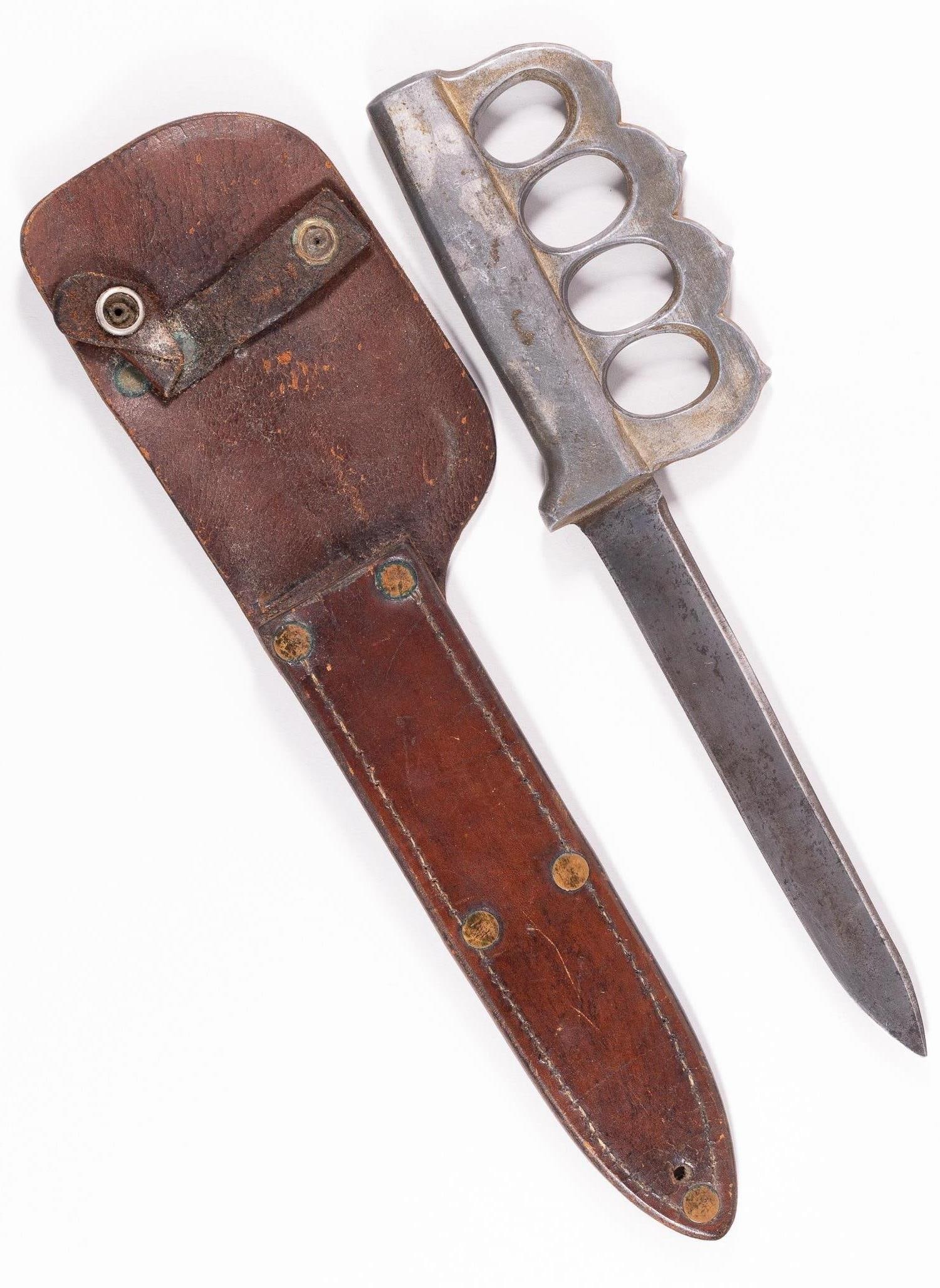 AUSTRALIAN/ NEW ZEALAND WWII FIGHTING KNIFE: Australian/ New Zealand WWII fighting knife. The knife feature an aluminum cast grip with pointed aluminum knuckles, steel blade is unmarked. Included is a rare to find brown leather scabbard, scabbar