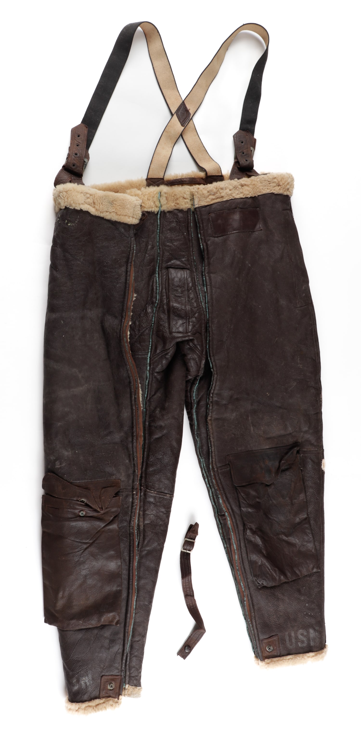 WWII US NAVY BU AERO WINTER FLIGHT TROUSERS M446 WILLIS AND GEIGER: Original WWII U.S. Navy leather and shearling wool winter flight pants with suspenders, leather ID a tag of owner 'L.T. (JG) R.C. Pinel. Each leg is stamped at the bottom 'USN'. Maker label reads 'Tro