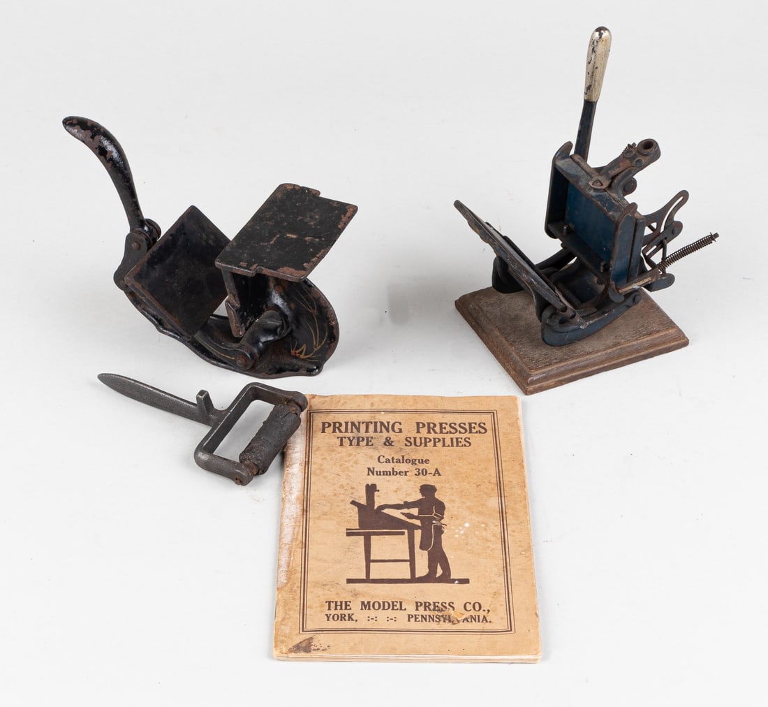 2 MINIATURE PRINTING PRESSES AND PRINTING SUPPLY BOOK: Two c. 1880s Miniature Printing Presses/Salesman sample presses with early York Printing Press and supply book. One of the presses has a painted design on both sides and the press lever is very stiff.