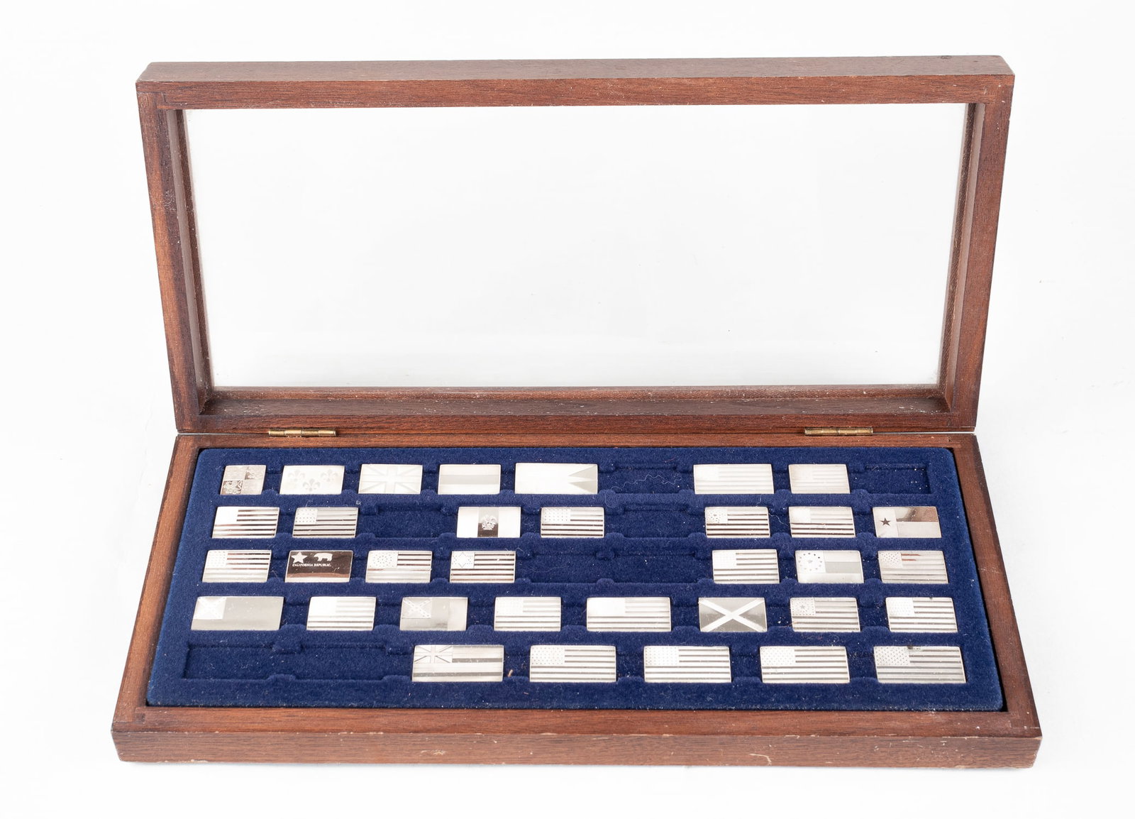 STERLING SILVER FLAGS OF AMERICA MINI-INGOTS: Thirty-four limited edition solid sterling silver flags by the Franklin Mint. The flags are in the original case with spaces for forty-two flags, eight flags are missing. Each flag has a description o