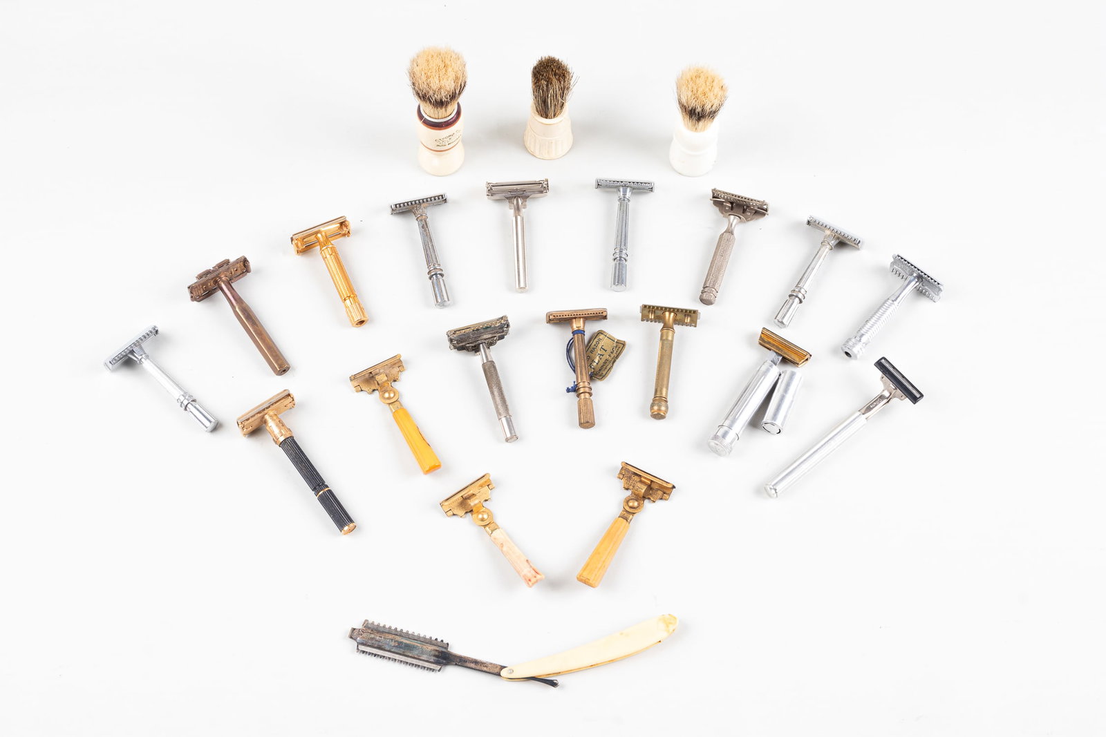 VINTAGE RAZORS: A collection of vintage shaving equipment such as razors, handles, and brushes.
