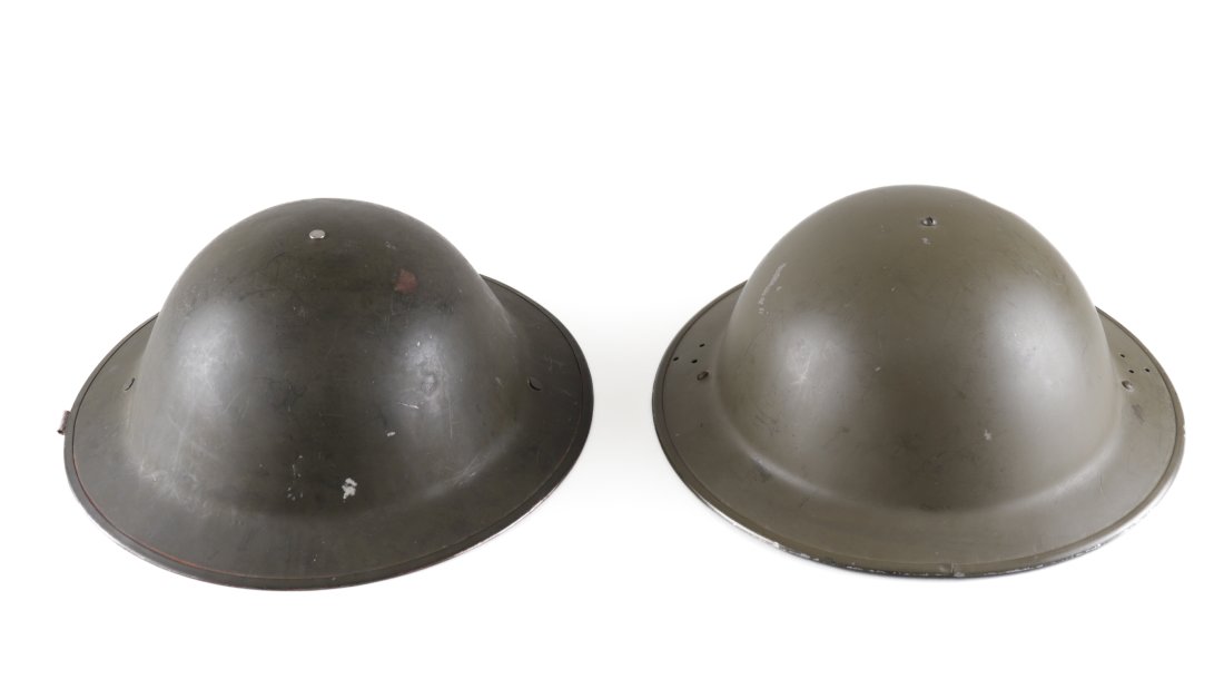 2 BRITISH WWII MK II HOME GUARD/CIVIL DEFENSE HELMETS: Two British MK II helmets for Home Guard/civil defense. The first is a British MK II No.2 Mark 1 combat helmet. The helmet has olive green paint with black leather lining and a green canvas chin strap