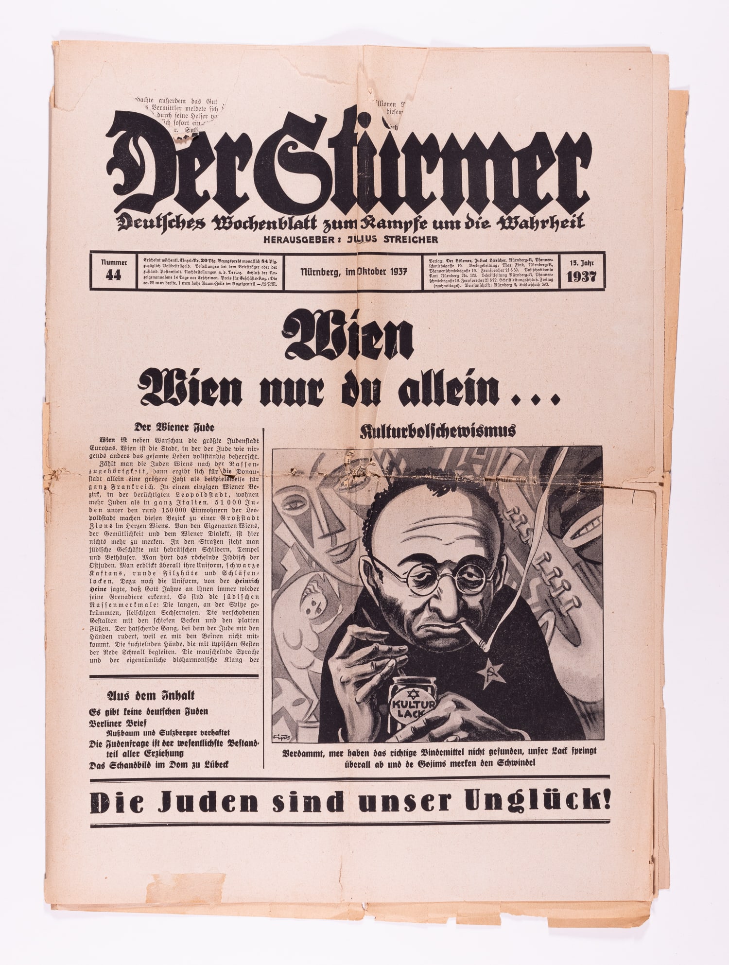 DER STURMER ANTISEMITC NEWSPAPER: 1937 original edition of Der Sturmer, Julius Streicher's virulent weekly propaganda tabloid. Headlined 'Vienna - Vienna You Alone...' with an antisemitic cover cartoon by Fips of a smoking Jew in fron