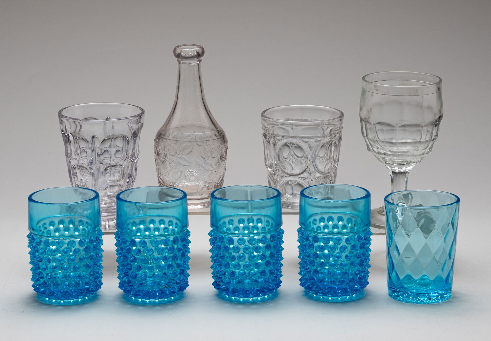 22 EAPG WINE GLASSES PUNCH CUPS AND TUMBLERS: Lot of twenty-two early American pattern glass punch glasses, wine glasses, and tumblers. All clear pattern glass unless stated otherwise. Featuring: 1. Four Pineapple and Fan punch cups. 2.25 inches.