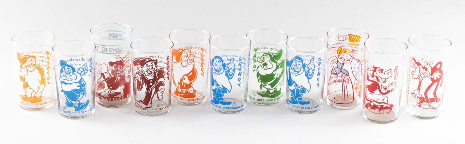 11 DISNEY JELLY GLASS: Eleven Disney character Jelly Glasses. A 'Walt Disney's Cinderella' 1960s 50th-anniversary promotional Jelly Glass. A 1939 Disney All Star Parade Jelly Glass featuring Donald and the Duck family. Seve