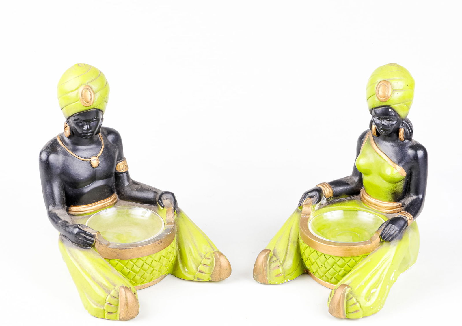 2 BLACK GENIE STATUES WITH BOWL INSERT: These 2 black genies are from 1954 created by the Statuary company. They feature the two genies, 1 man and 1 woman, holding a bowl insert in their hands. The genies are made from a ceramic and the bow