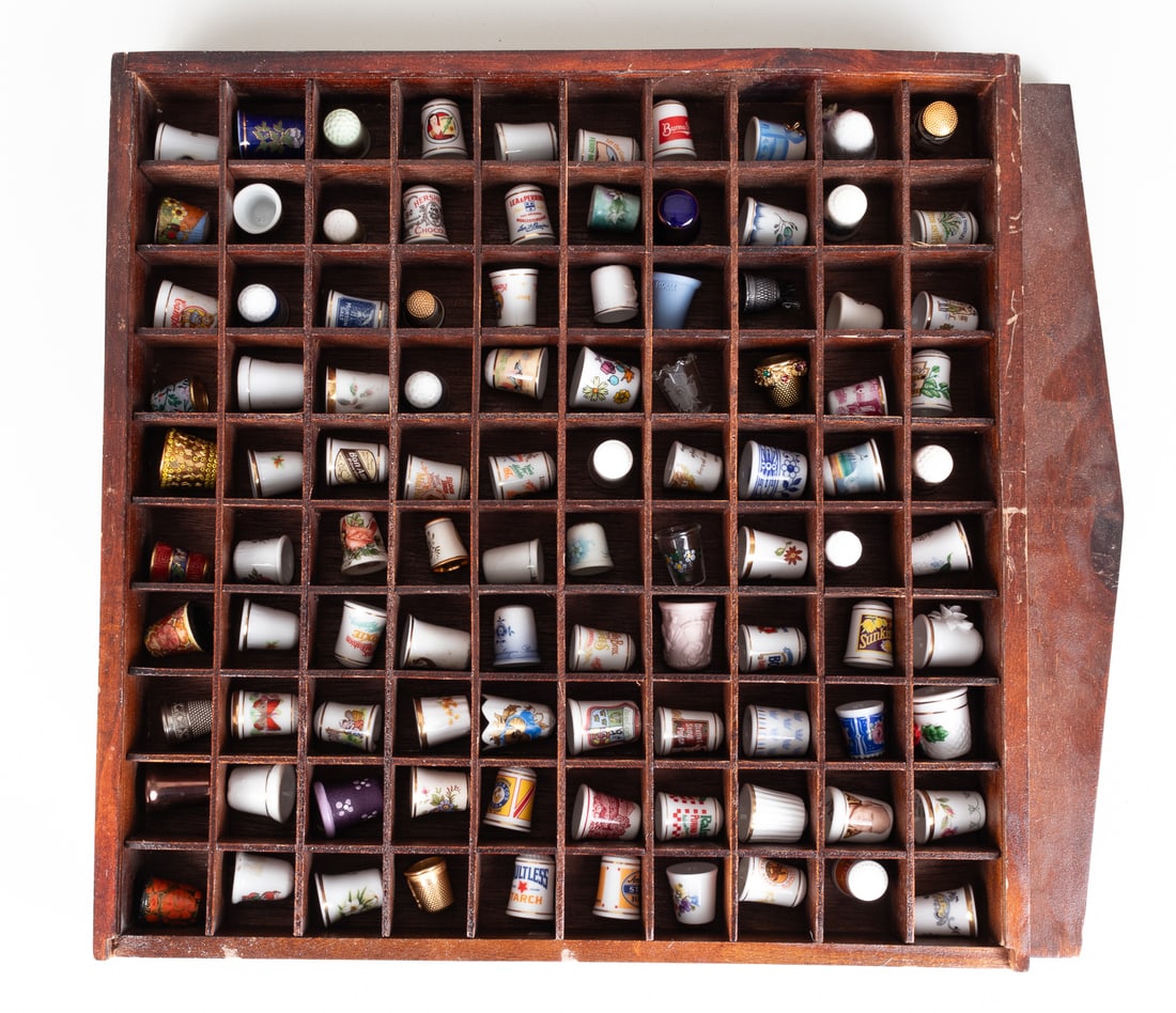 LARGE COLLECTION OF THIMBLES: Large group of one hundred (100) knitting thimbles. Featuring various designs made of porcelain, bone china, wood, glass, and metal (gold and silver toned).