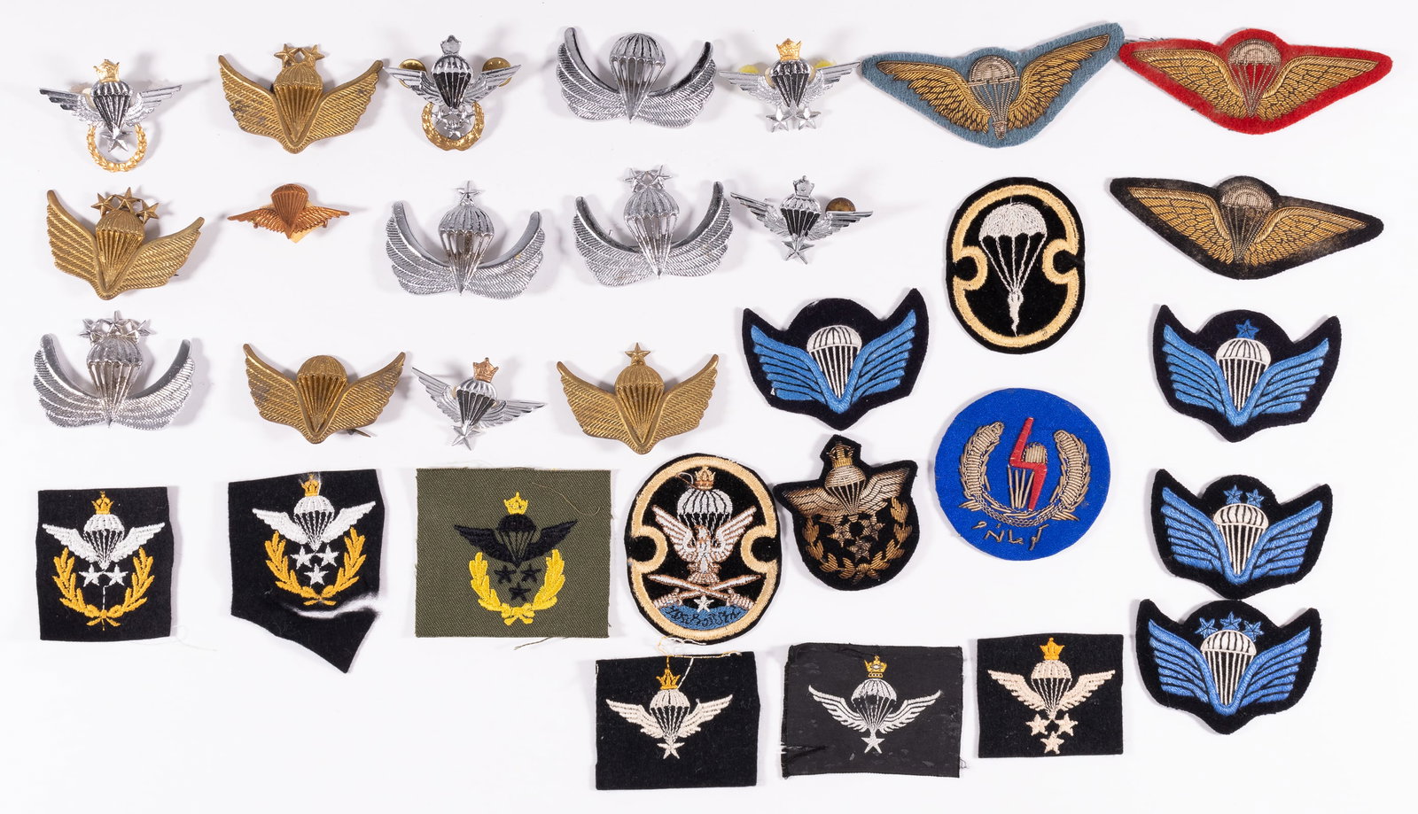 AFGHAN AND IRAN PARATROOPS WINGS BADGES AND INSIGNIA: 31 Afghan and Iran patches and brevets. 15 Iranian Paratroops Wings badges and sleeve insignia, featuring: 1) five Parachutist Jump Wings with Crown brevets, featuring basic to master senior class. 2)