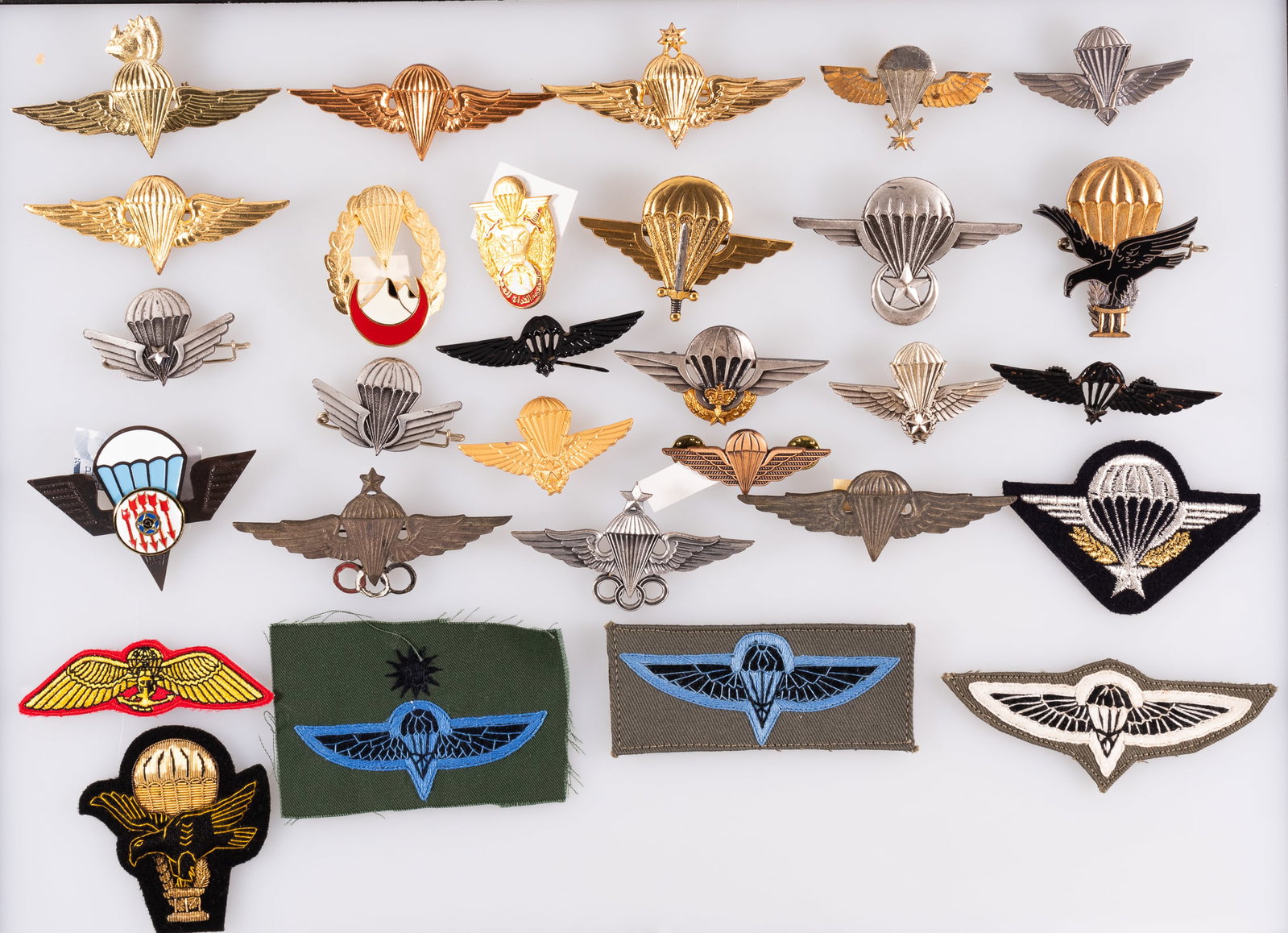 AFRICAN PARATROOPS WINGS BADGES AND INSIGNIA: 29 African Paratroops Wings badges and sleeve insignia, featuring: 1) three Nepal Parachutist Jump Wings sleeve patches 2) Mauritania Airborne Parachute Wings badge 3) three Moroccan Parachute Wings b