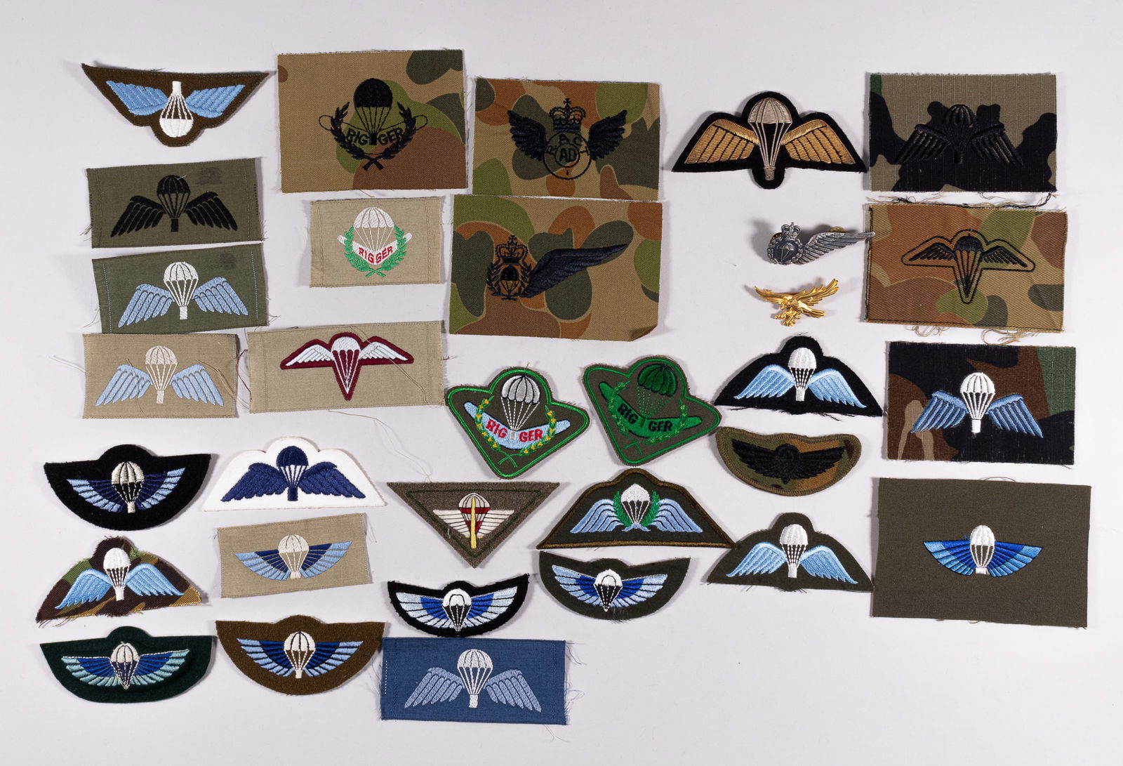 BRITISH AND AUSTRALIAN PARATROOPS WINGS BADGES AND INSIGNIA: 32 Australian and British Paratroops Wings badges and sleeve insignia, featuring: 1) Royal Navy Gaurd Wings patch 2) Royal Army instructor Wing pin 3) twelve British SAS Parachutist Wings patches, for