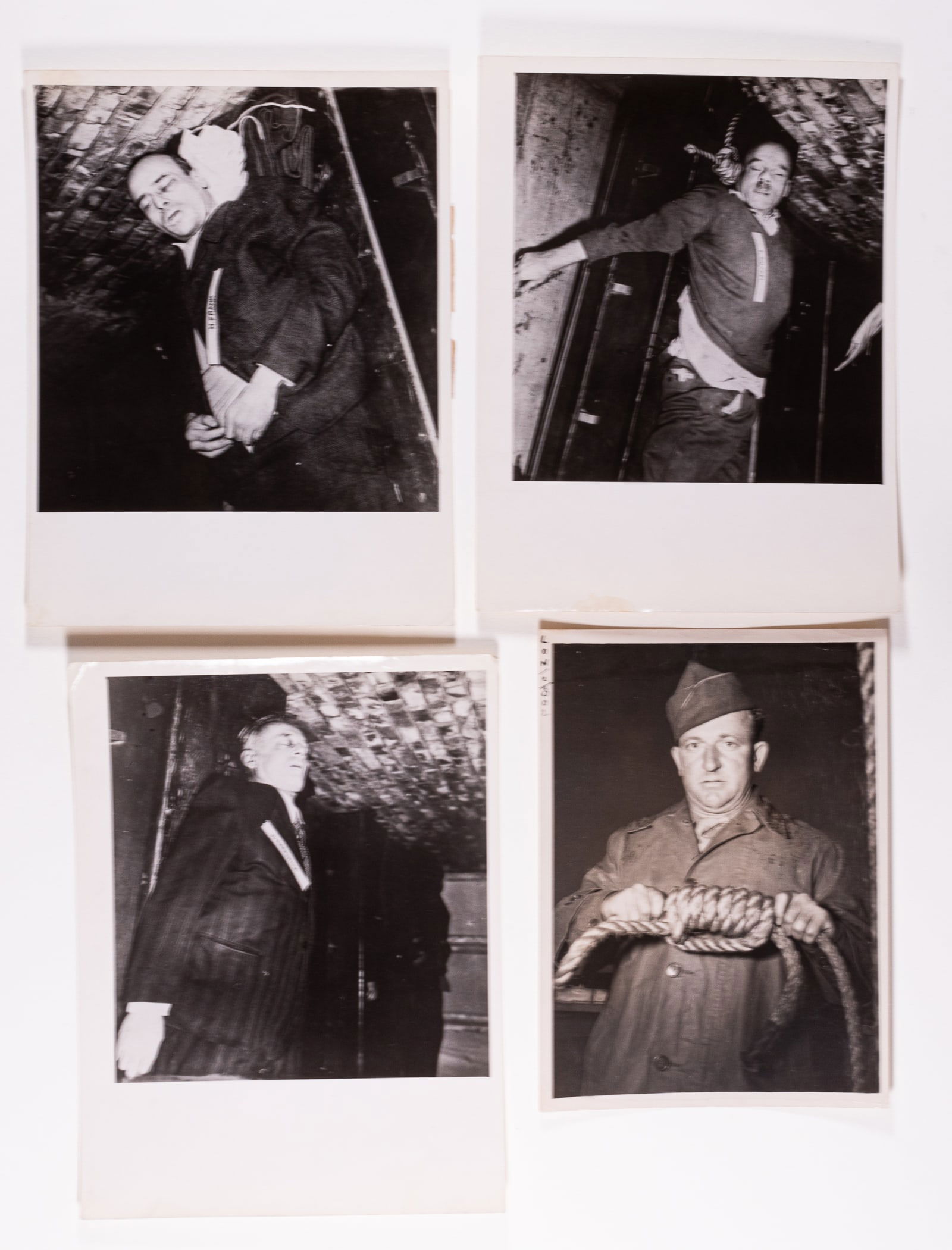 NUREMBERG TRIAL EXECUTED PRISONERS PHOTOS: Lot of four b/w press photographs of executed prisoners and the executioner from the Nuremberg Trial in 1946. Photographs show the dead bodies of Hans Frank, Joachim von Ribbentrop and Fritz Sauckel,