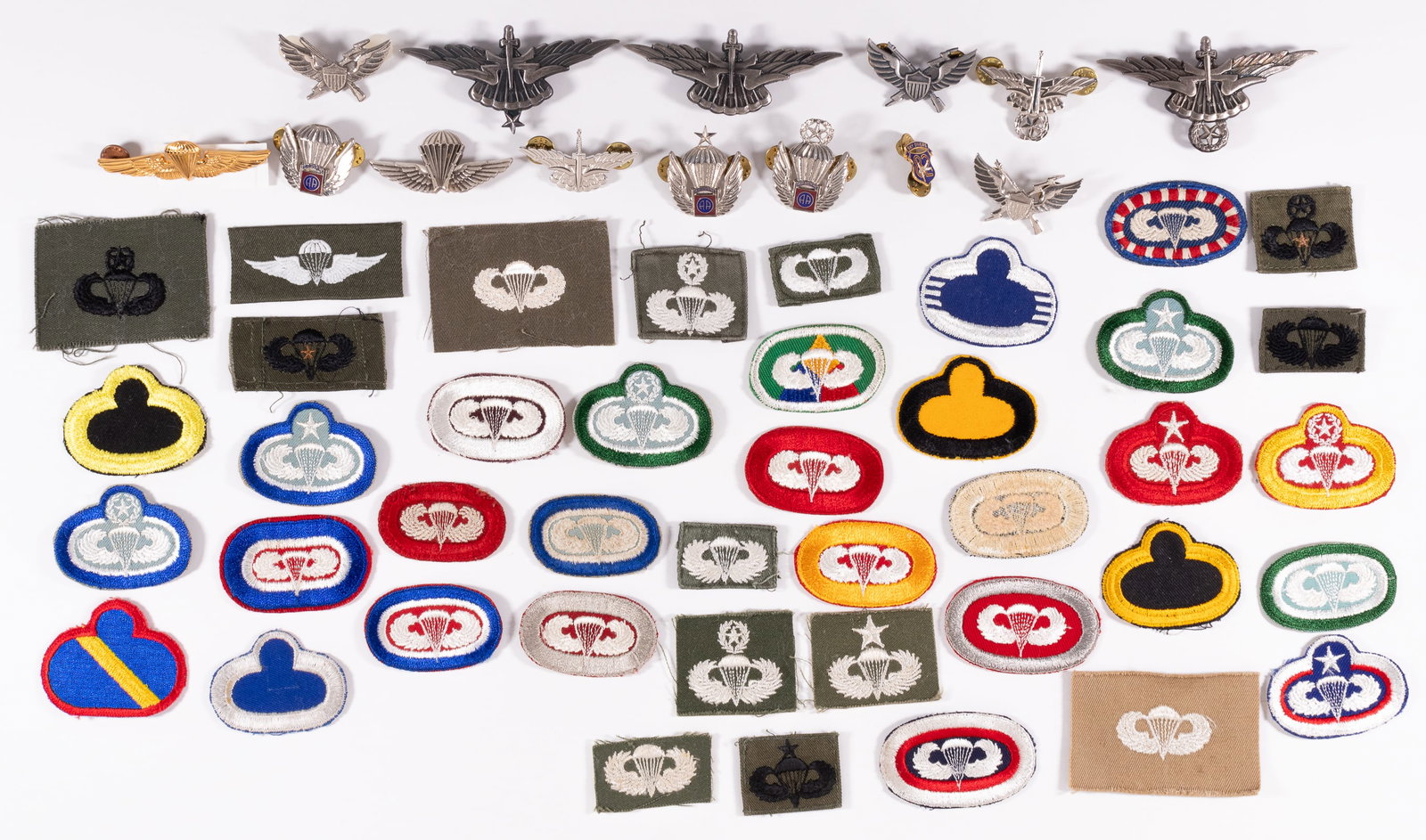 US PARATROOPS WINGS BADGES AND INSIGNIA: 55 United States Paratroopers Wings badges and sleeve insignia, featuring: 1) five Proposed Freefall Wings, two basic, one senior, and two master class badges. 2) three 11th Airborne parachutist patch