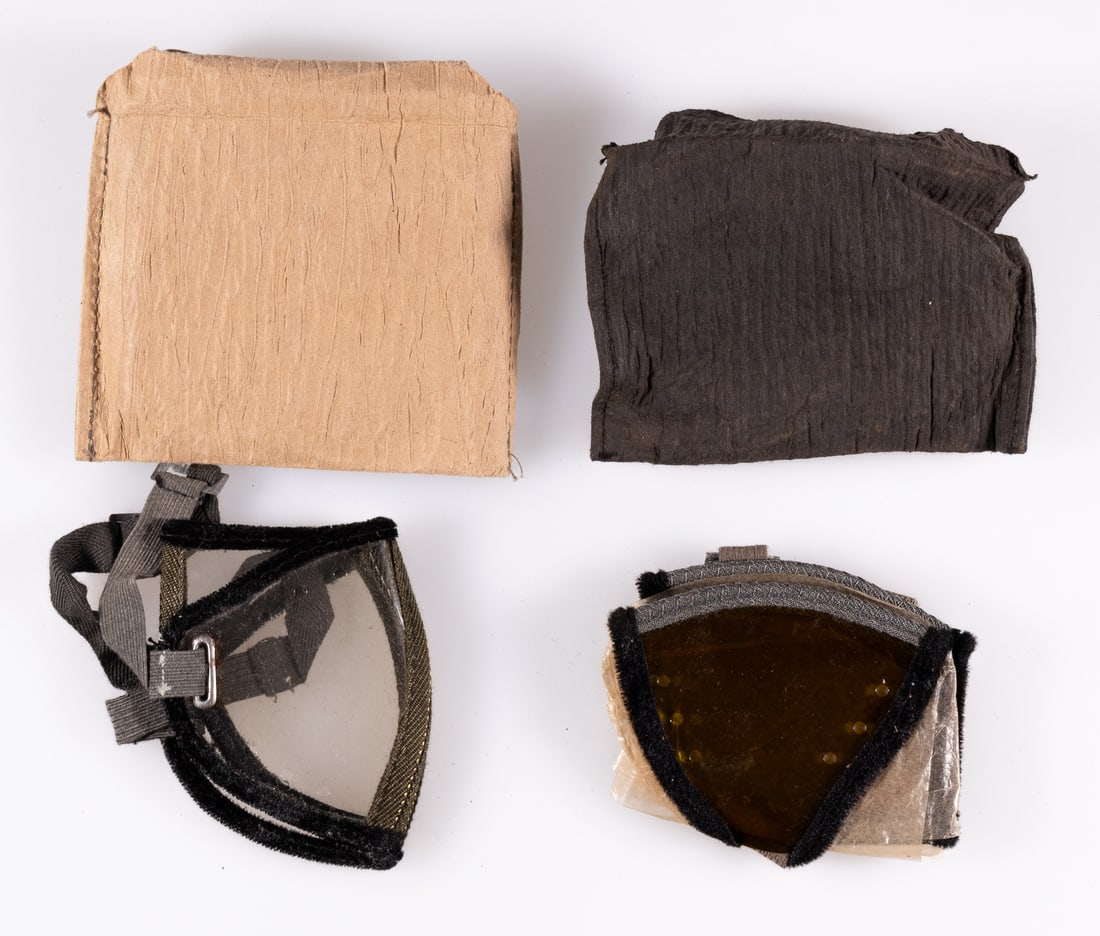 GERMAN AFRIKA KORPS SAND GOGGLES 2 PAIRS: Two pairs of German Afrika Korps sand goggles, used by German soldiers to help keep sand out of their eyes. Both in original packaging. Both pairs are made of clear foldable lenses, with grey straps h