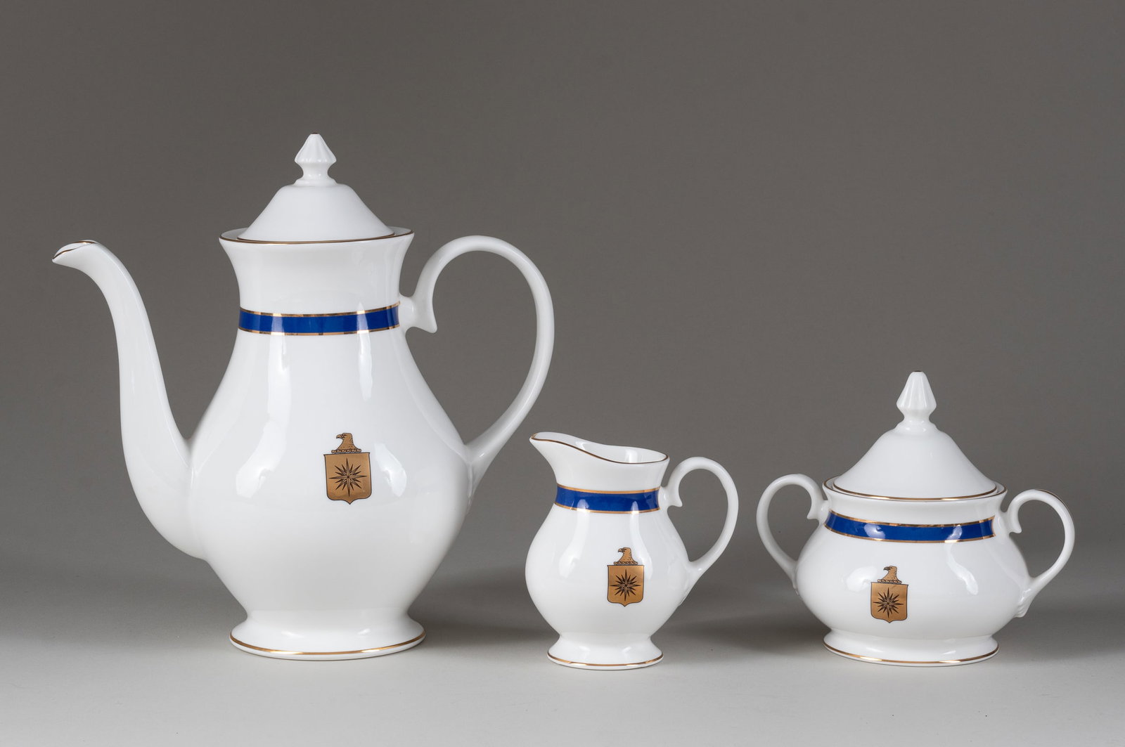 CENTRAL INTELLIGENCE AGENCY COFFEE SET: US Central Intelligence Agency (CIA) three-piece bone china coffee set, including a coffee pot with lid, 7.25 inches tall; creamer, 4 inches tall; and sugar bowl, 3 inches tall. Coffee pot and sugar b
