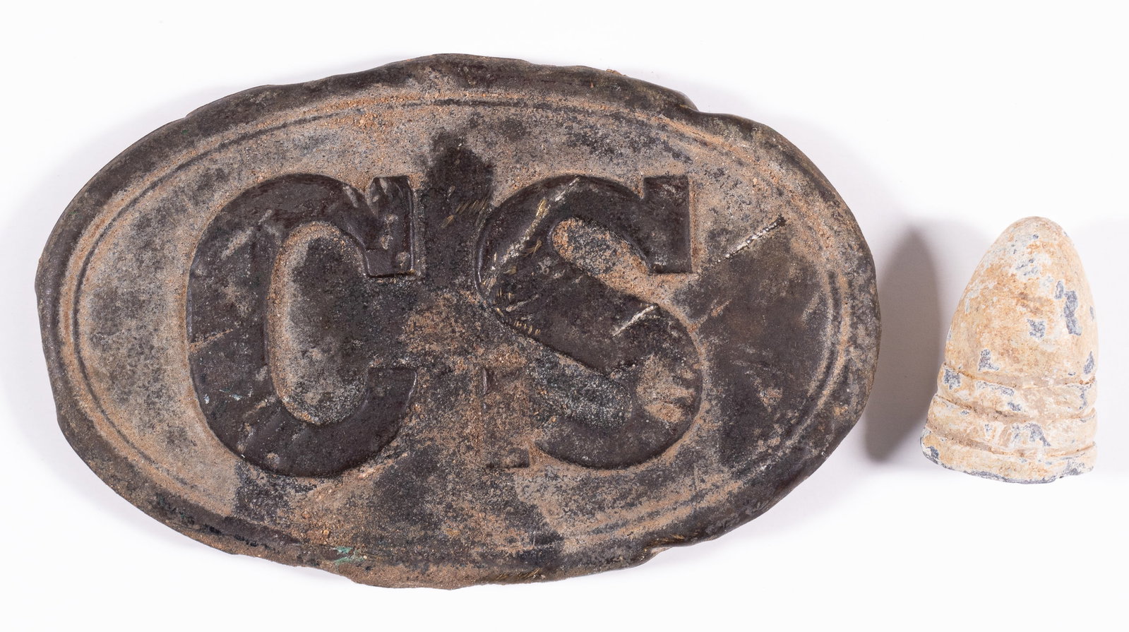 CIVIL WAR CONFEDERATE SOLDIER BELT BUCKLE: Civil War Confederate soldier 'CS' belt buckle, 3.25 inches long. Shows significant wear to the front and back, with many knicks and catches. With a bent civil war style bullet that shows major wear l