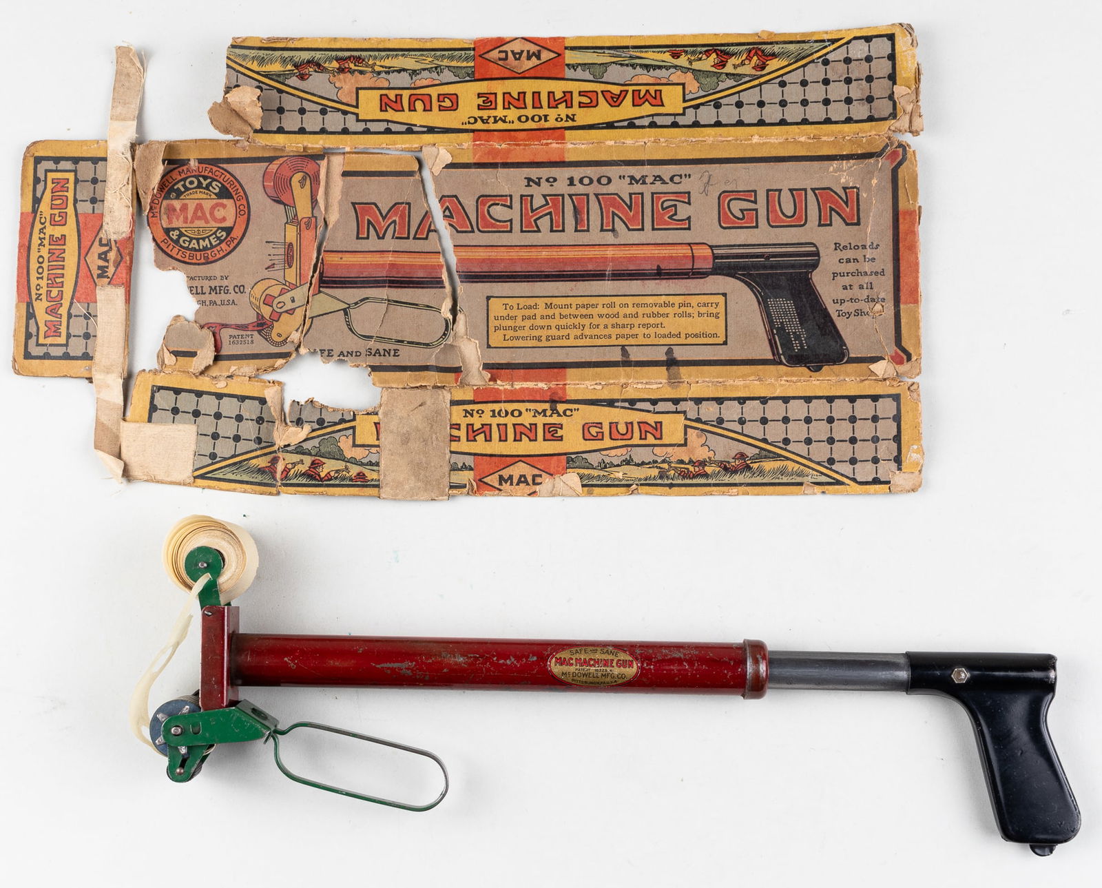 NO. 100 MAC MACHINE GUN TOY: McDowell Manufacturing No. 100 Mac Machine Gun toy, pressed steel toy from the 1930s. 12.25 inches long. With the original box, 13 x 4.25 x 2 inches, the box is ripped and torn along the left side.