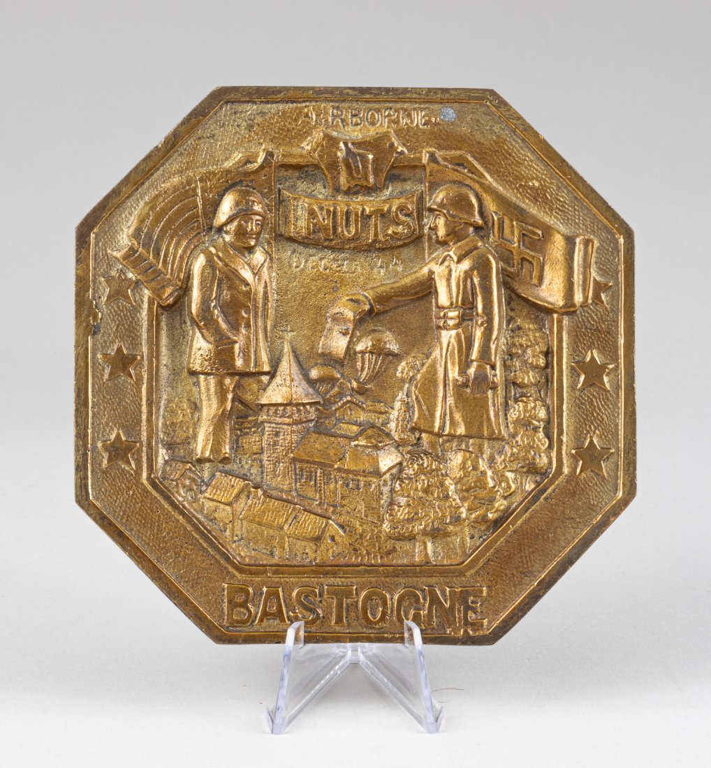 WWII 101ST AIRBORNE BASTOGNE NUTS BRASS PLAQUE: 'AIRBORNE - NUTS DEC 44 - BASTOGNE' Bronze plaque commemorating the famous battle of Bastogne made from spent brass shells. Bastogne was held by Americans and surrounded by the XLVII Panzer Corps. On 