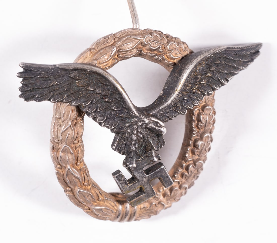 WWII GERMAN LUFTWAFFE PILOT'S BADGE DEUTSCHBEIN: Luftwaffe Pilot's badge by Deutschbein. The pilot badge features a swooping eagle clutching a mobile swastika in it?s talons. The eagle is superimposed on a wreath of half laurel and half oak leaves. 