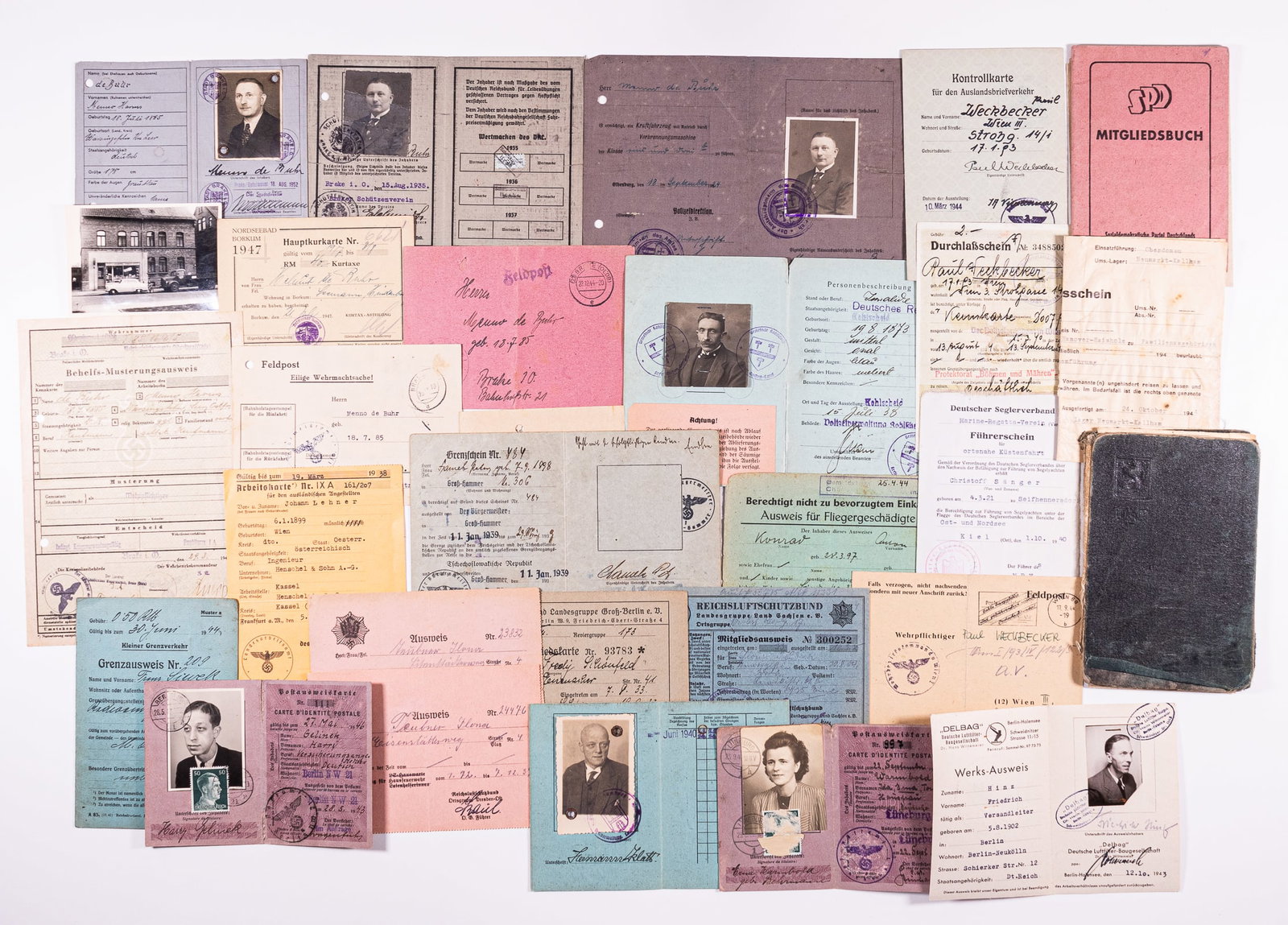 WWII GERMAN IDS AND PASSES (20+): WWII German ephemera grouping with over 20 IDs and passes. Includes passes with identity photographs, border passage certificates, a conscription certificate, work id's, personal id's, Reichsluftschut