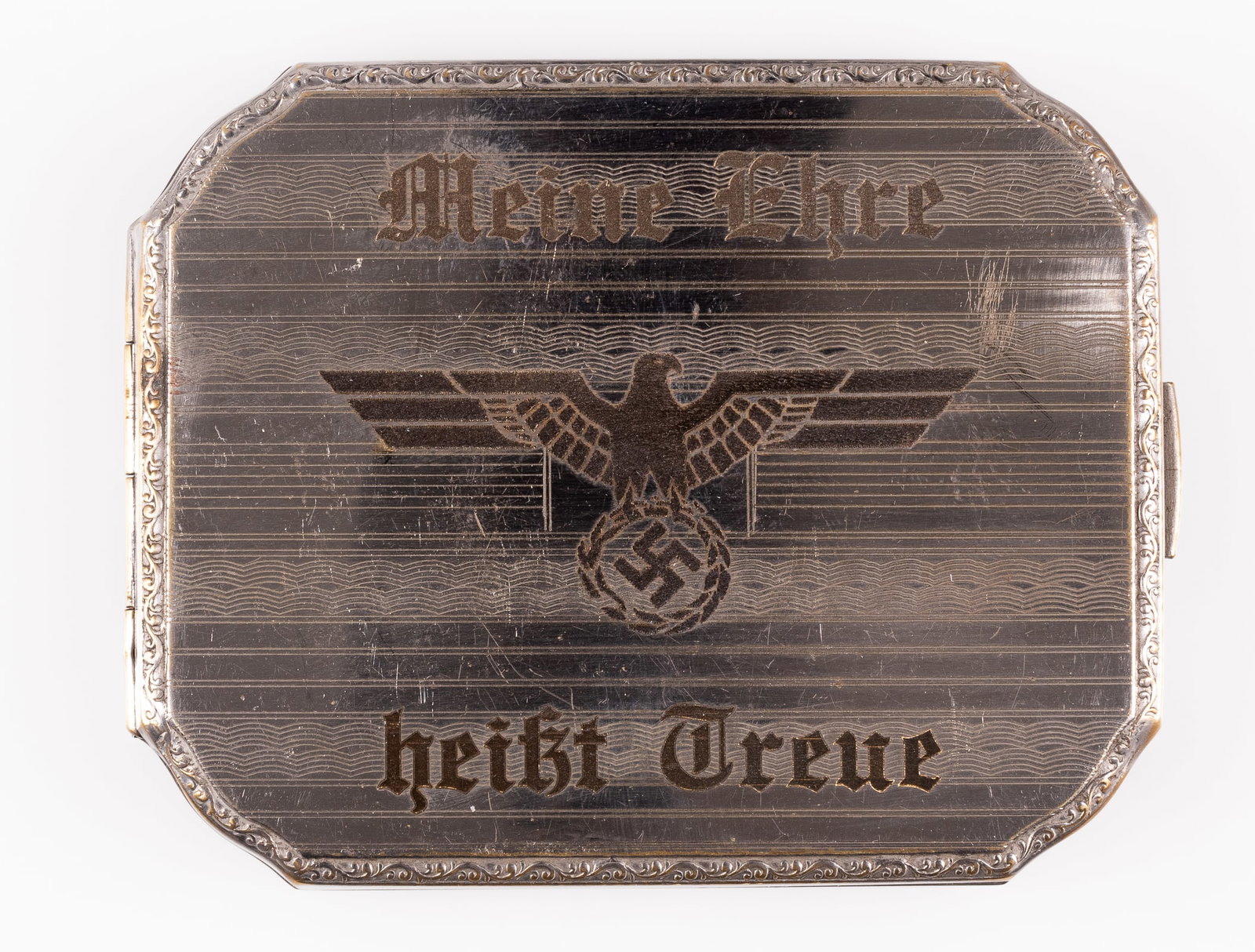 MEINE EHRE HEISST TREUE CIGAREETE CASE: Cigarette case engraved with the motto 'Meine Ehre - Heisst Treue' with the German SS eagle in the center. Unmarked, 4 x 3 inches.