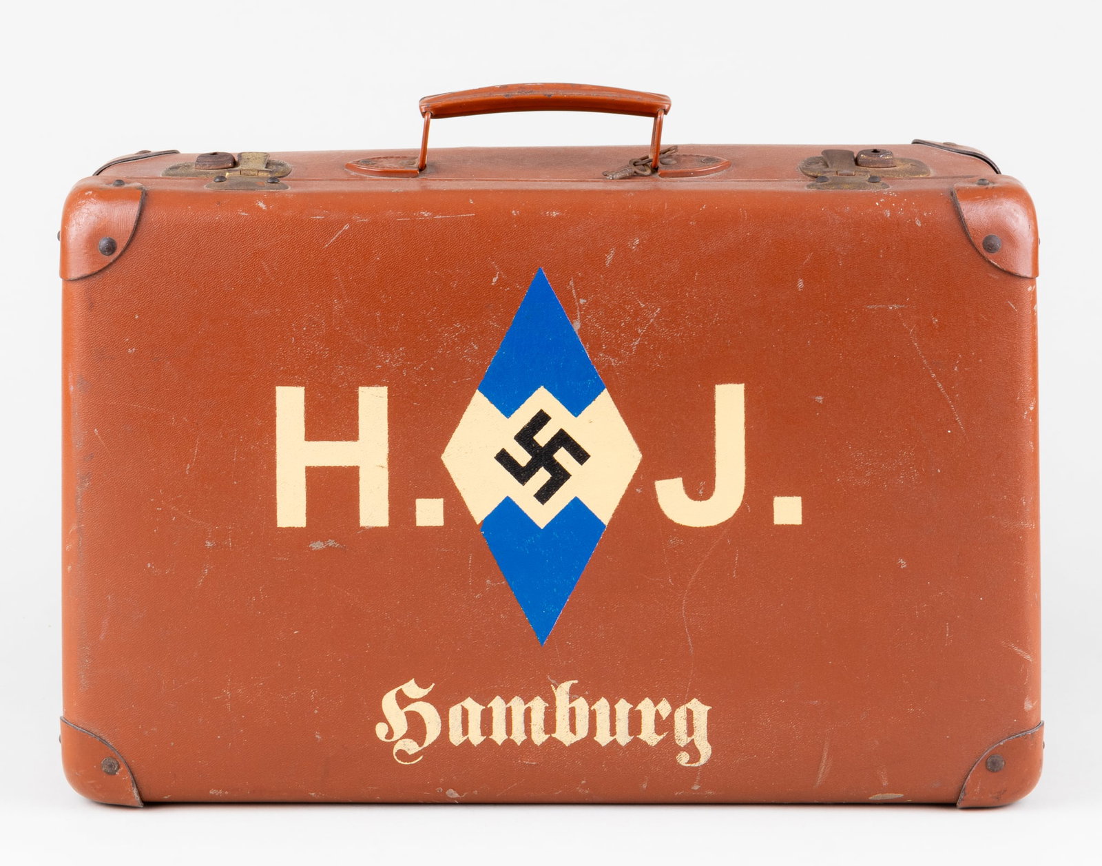 HITLER YOUTH SUITCASE: Bakelite suitcase of a Hitler Youth, painted on the front is a large blue Hitler Youth diamond, flanked by white letters 'H.J.', the German abbreviation for Hitler Jugend. 'Hamburg' is painted in whit