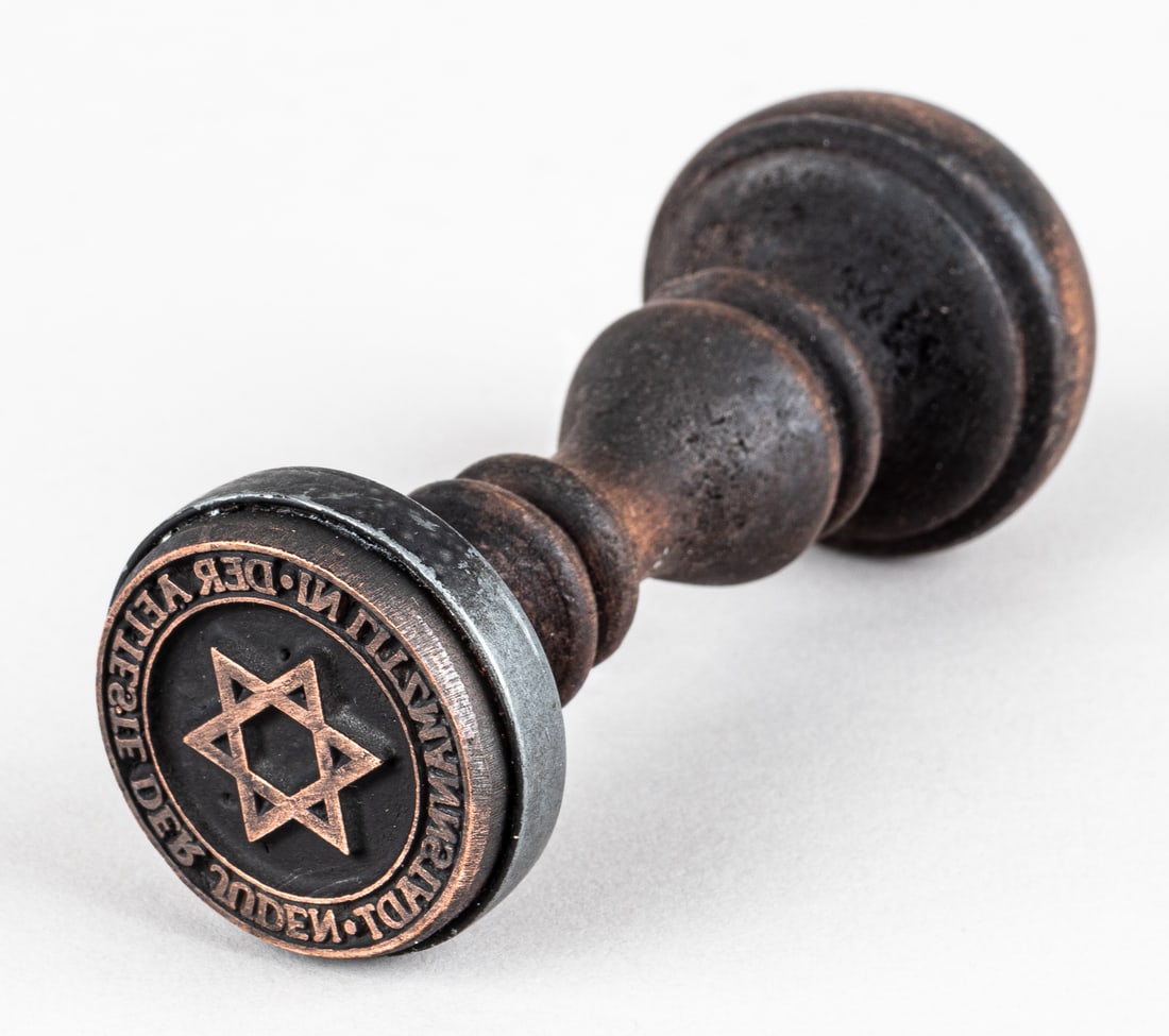 ELDERS OF THE JEWS LITZMANNSTADT GHETTO HANDSTAMP: WWII Litzmannstadt Ghetto handstamp with a wooden handle. The stamp reads 'Der Aelteste Der Juden In Litzmannstadt' (Elders of the Jews in Lodz Ghetto), around a Star of David. It measures 4.5 inches