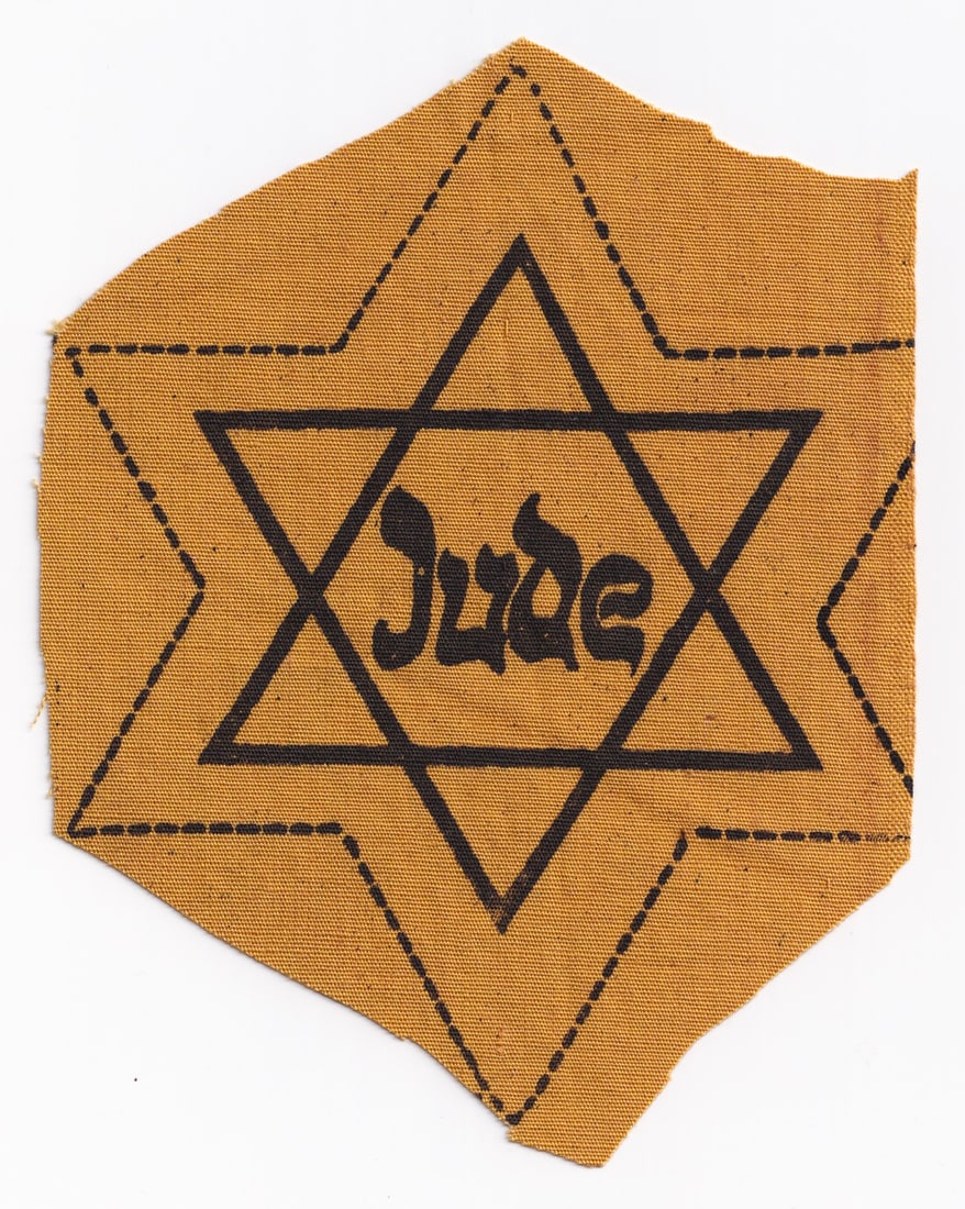 JUDE JEWISH YELLOW STAR OF DAVID: Scarce Third Reich yellow Jude Star of David or 'Judenstern', a six-pointed star made of yellow fabric with the word 'Jude' printed in the center in black letters, imitating Hebrew writing. The star h