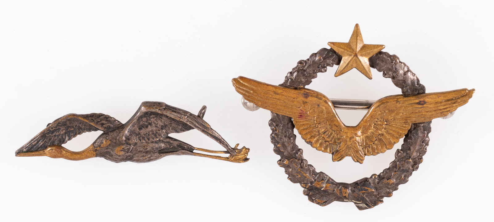 2 WWII FRENCH AVIATION CAP BADGES: Lot of two WWI French cap badges, including a Pilot Wings cap badge, marked '160' on the reverse, and a Stork Aviation Squadron pin.