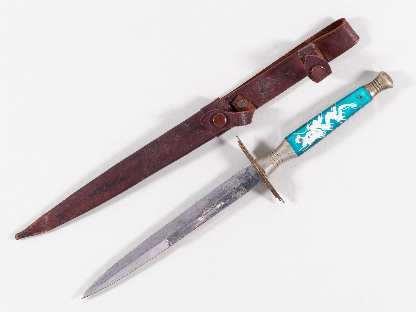 CHINESE SOUVENIR DAGGER W/ SHEATH: Chinese souvenir dagger with leather sheath, dragon design on the ricasso and grip, 5.75-inch blade, 10 1/8 inches total.