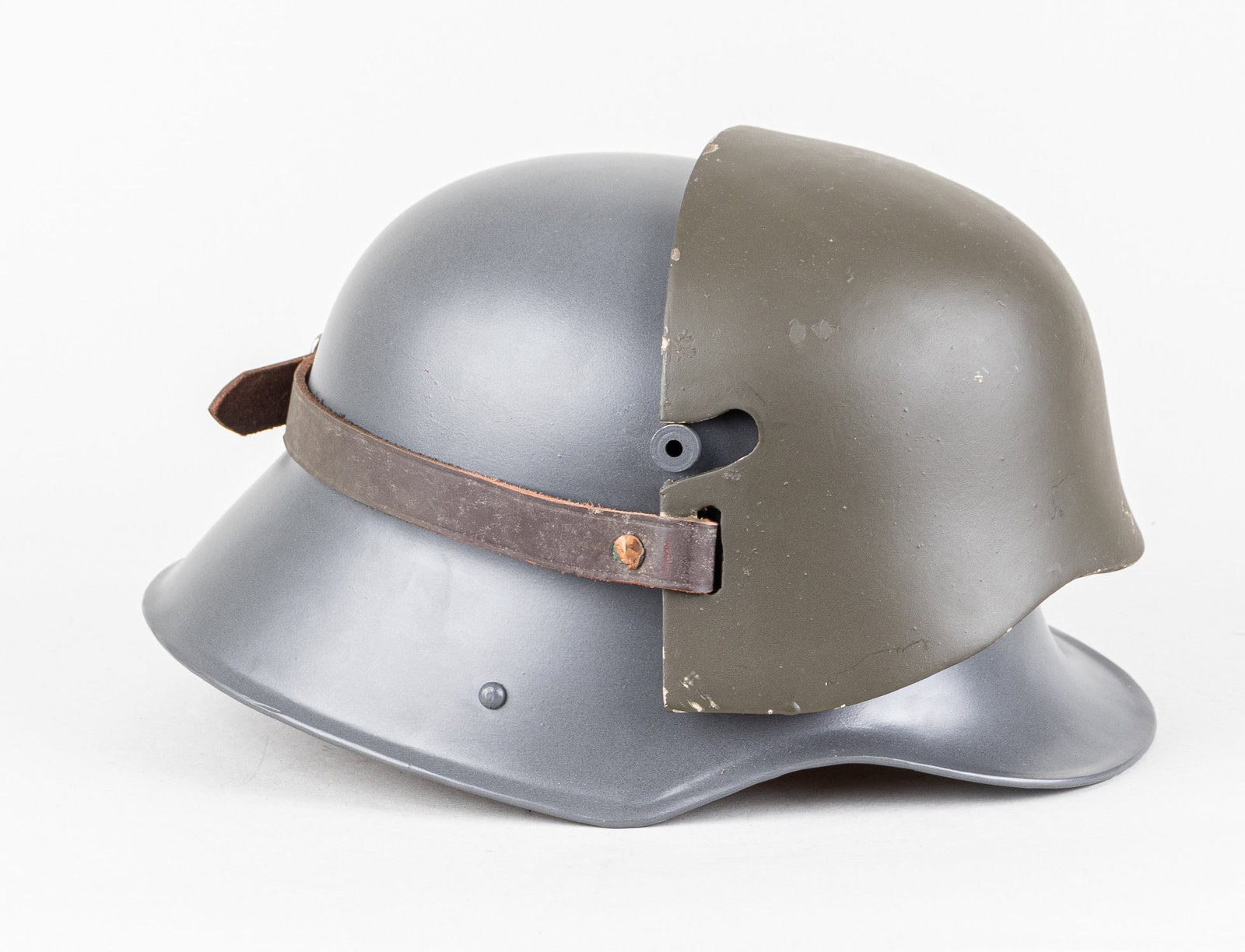 IMA GERMAN MODEL M16 HELMET W/ STIRNPANZER: IMA made collector's model of the WWI M16 helmet with Stirnpanzer. The helmet is made out of steel painted in field grey and features a heavy steel Stirnpanzer painted in a grey-green color held in pl